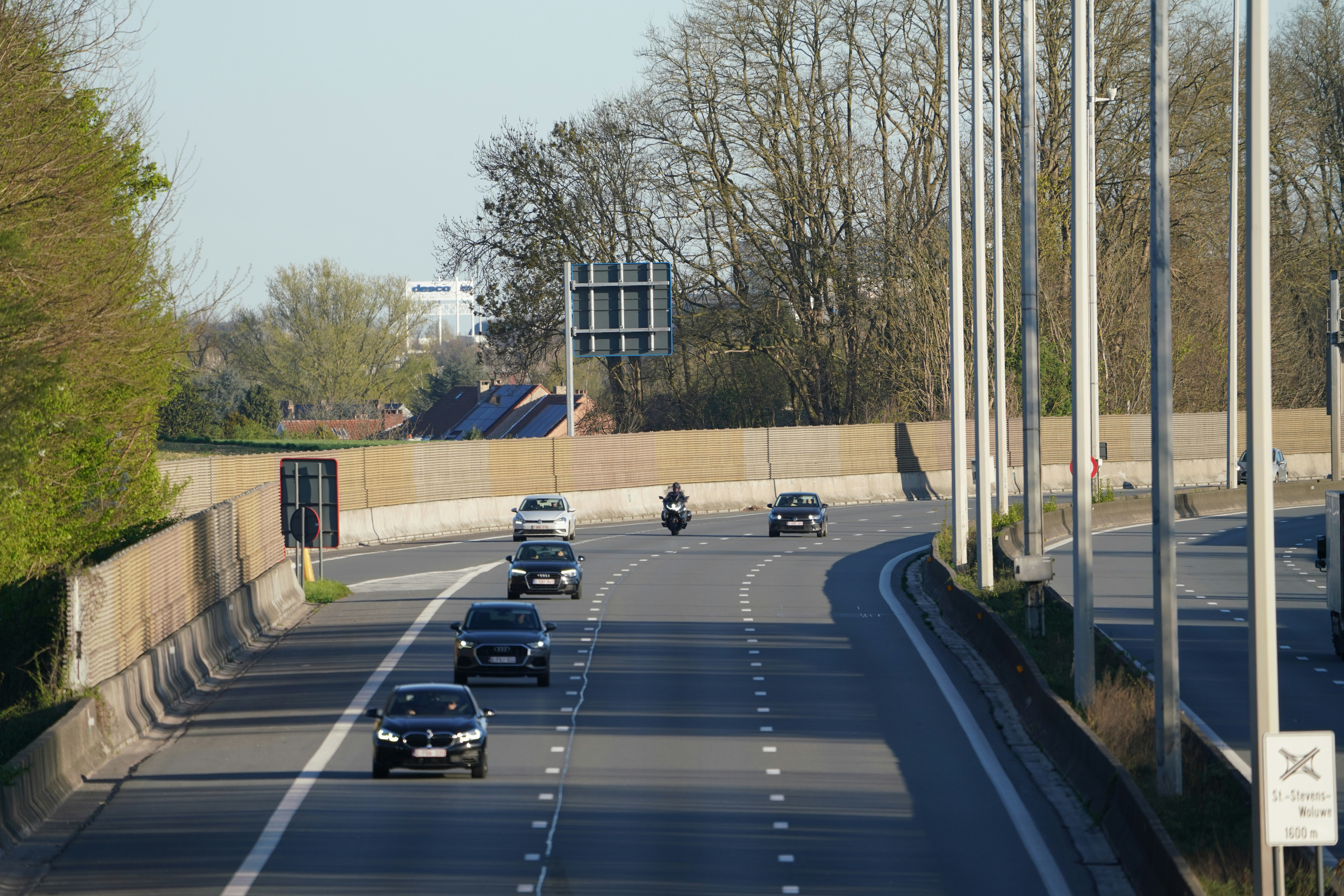 Cars and a motorcycle drive on the highway.