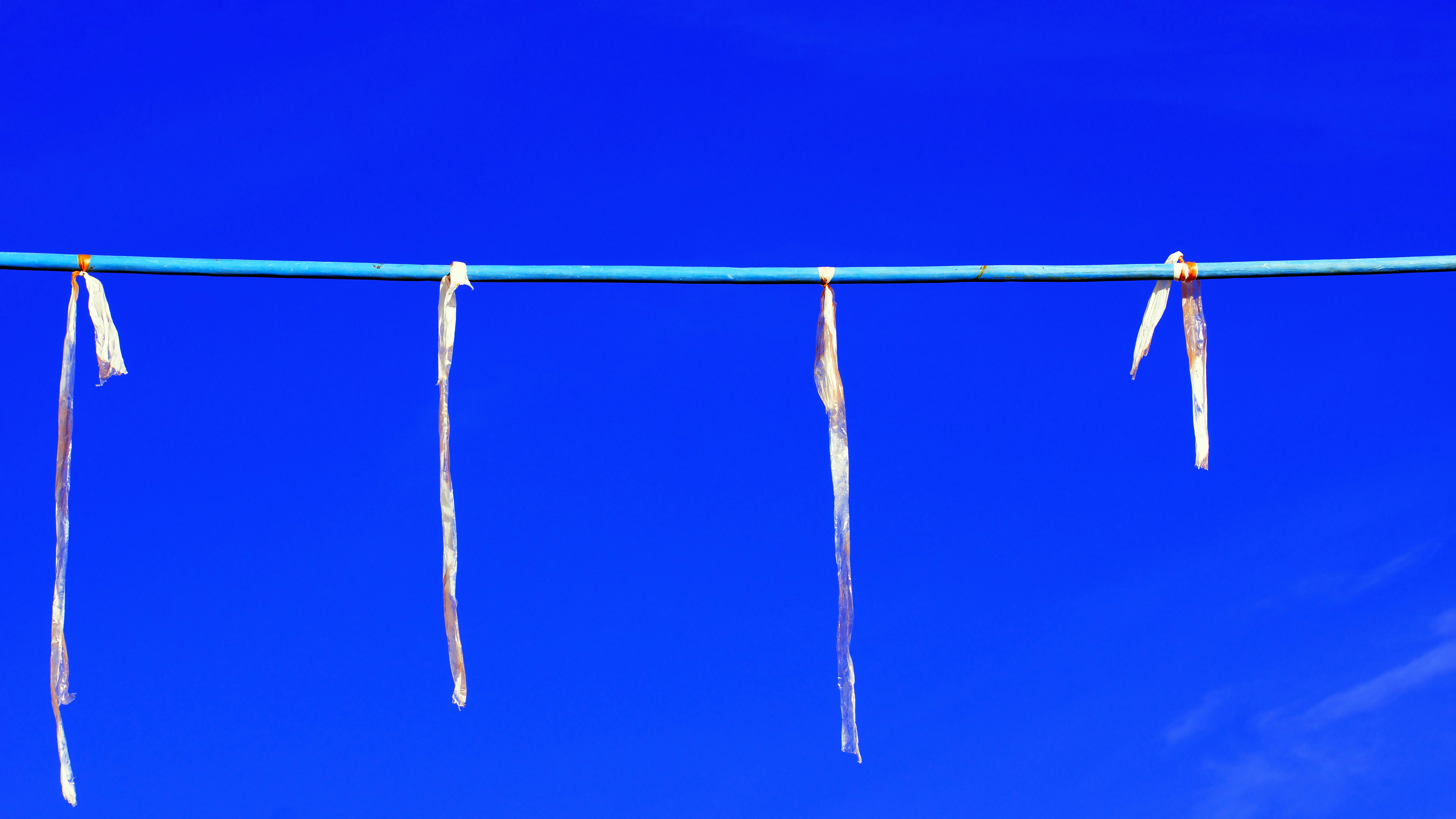 Ribbons hang from a blue rope in front of blue sky. photo – Free Snow ...