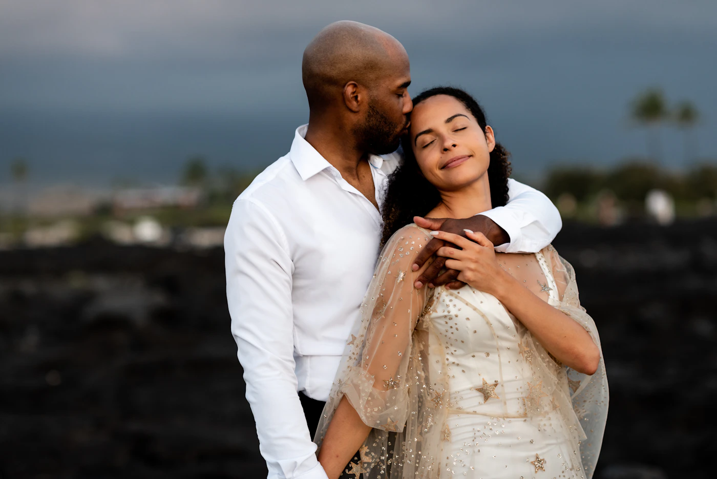 Couple in elopement attire on a boat during their San Andrés elopement trip with the turquoise Caribbean water and the island visible in the background