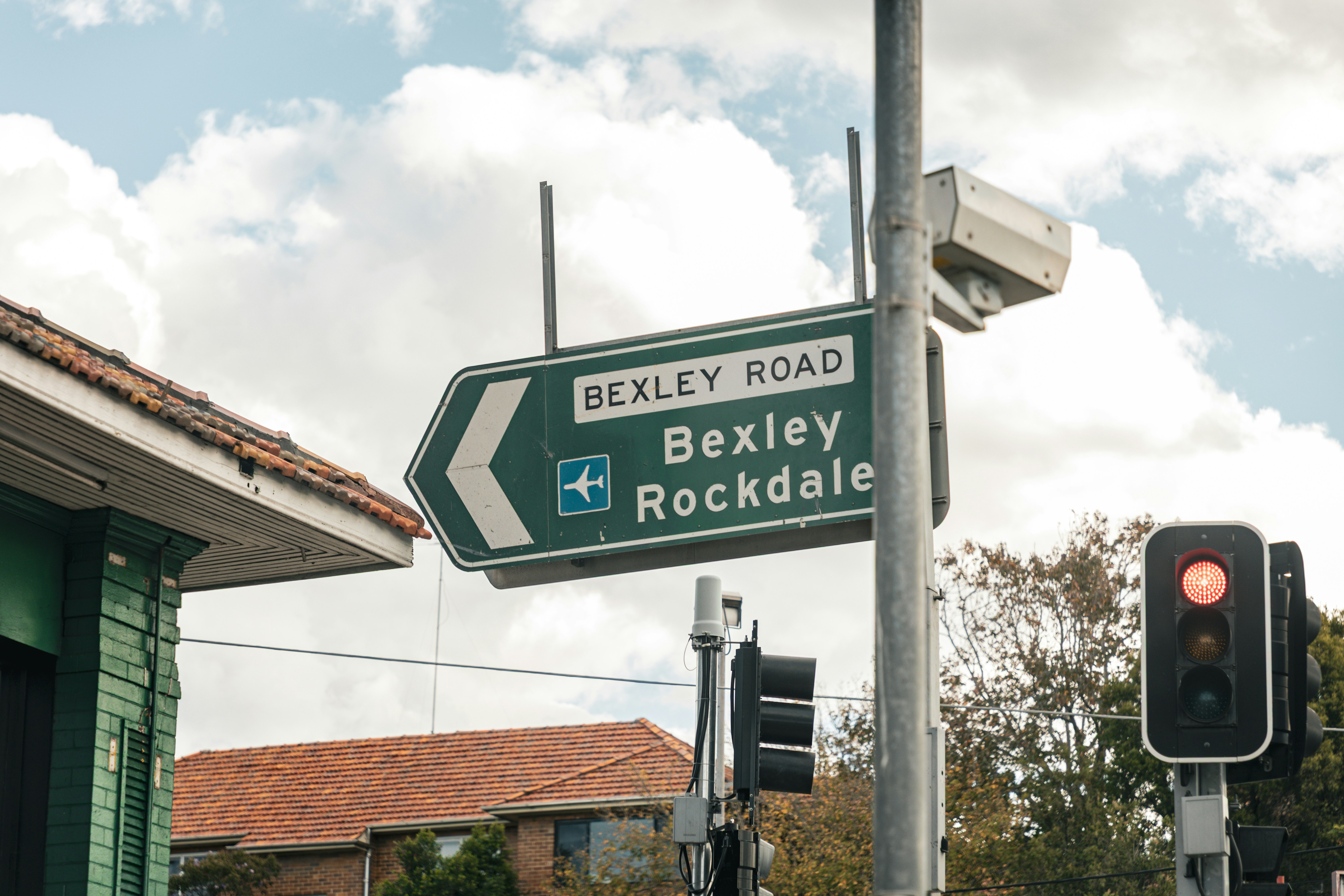 A green street sign points to bexley road