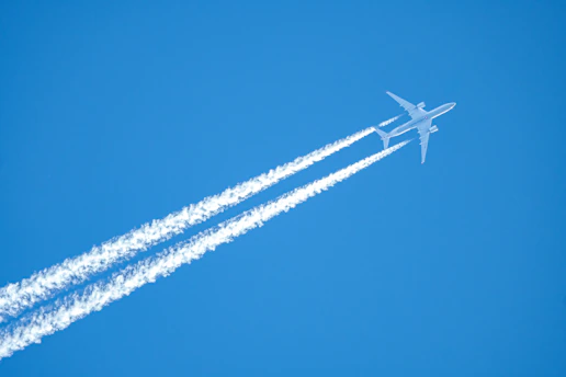 An airplane leaves contrails in a clear blue sky.