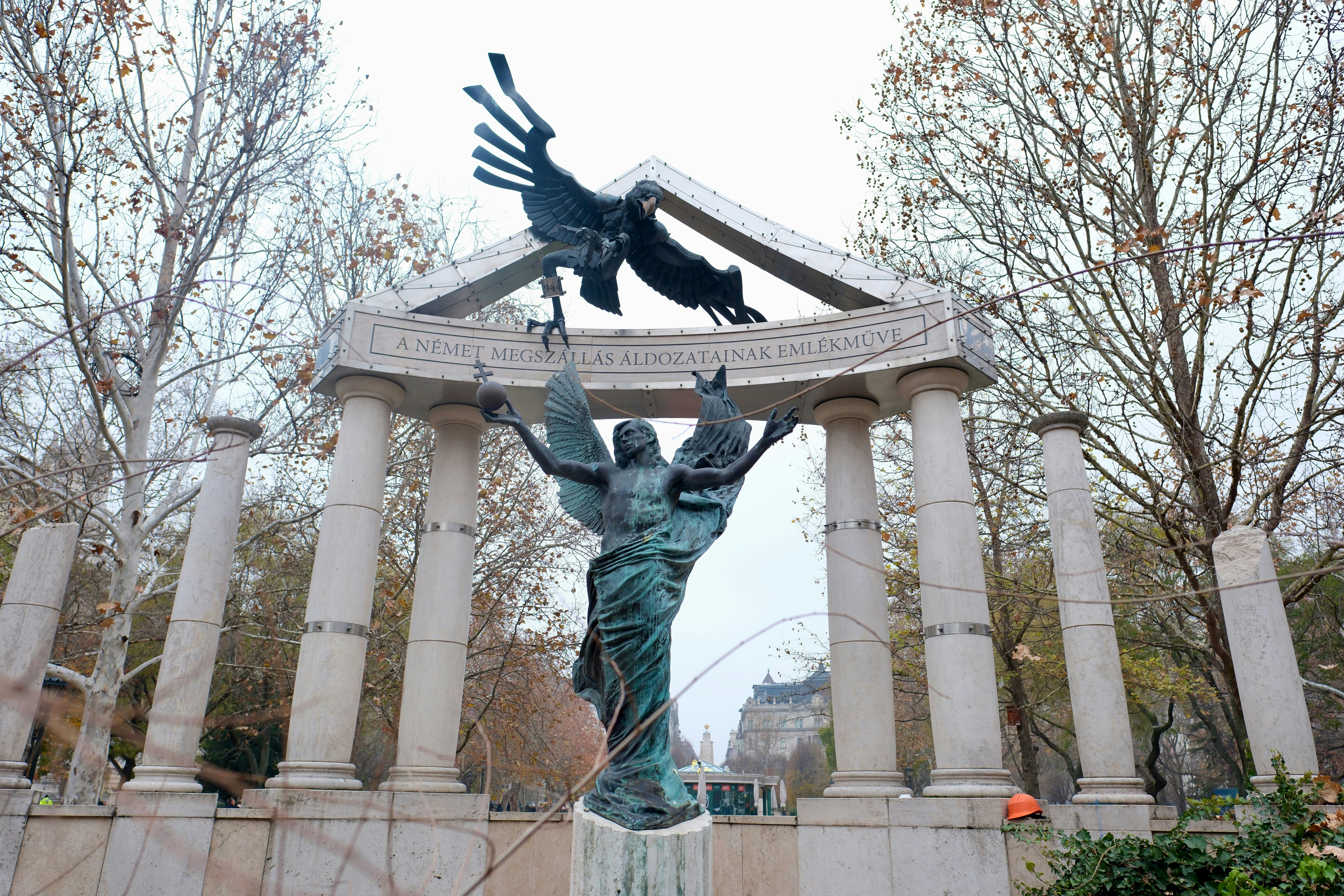A monument with sculptures, columns and trees.
