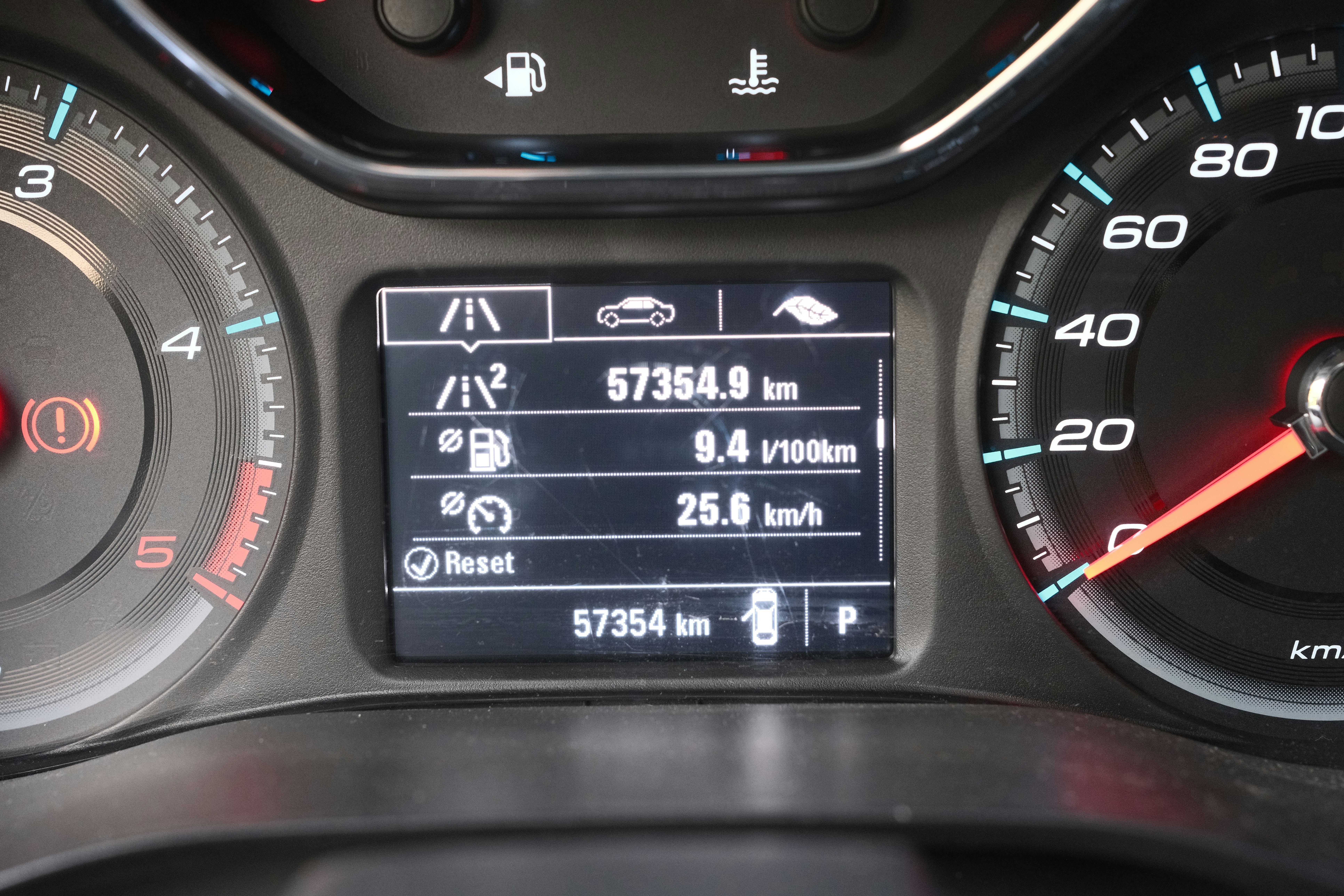 Closeup of a gas car dashboard showing a low fuel gauge warning