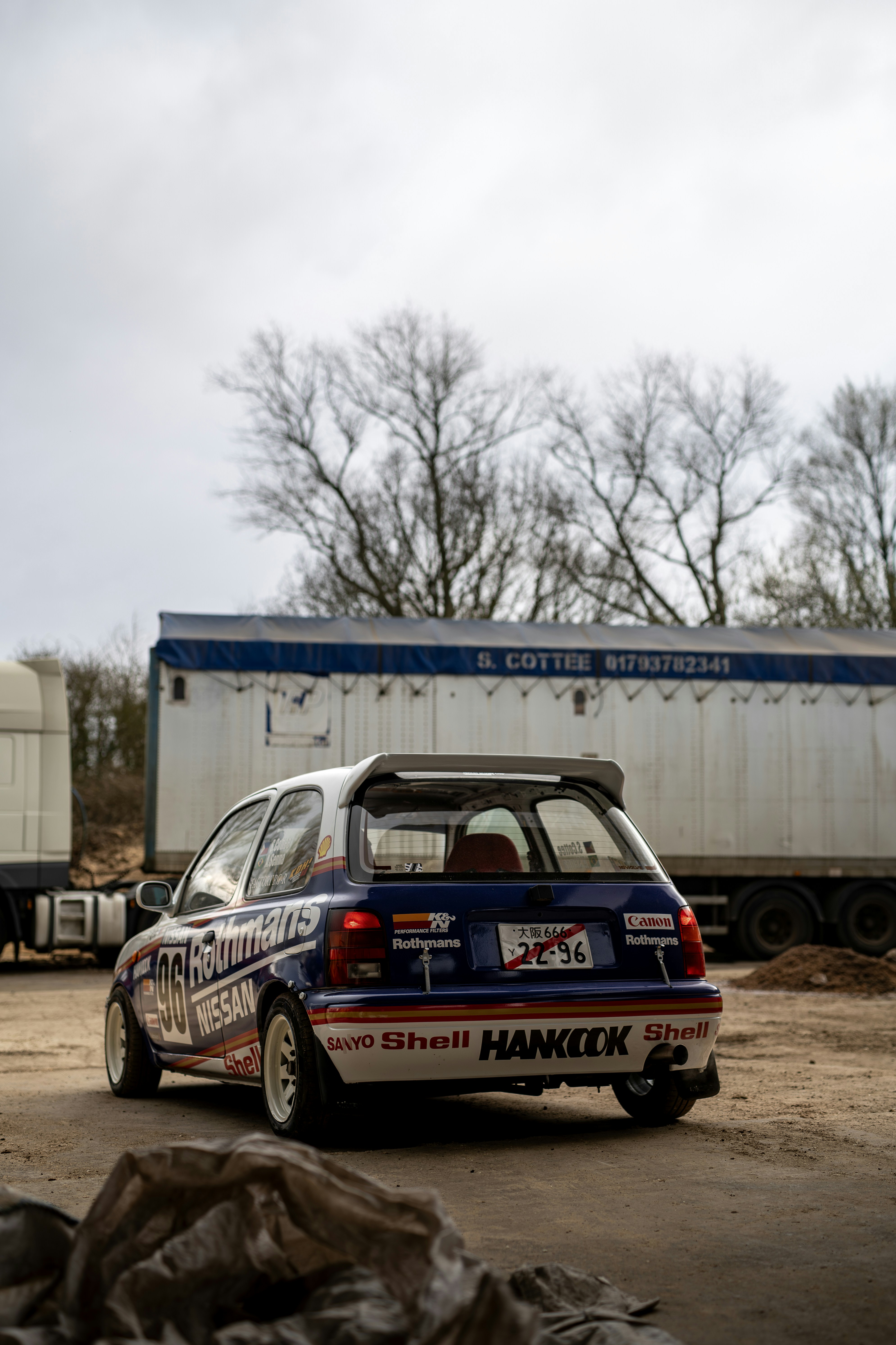 A blue and white racing car sits outdoors.