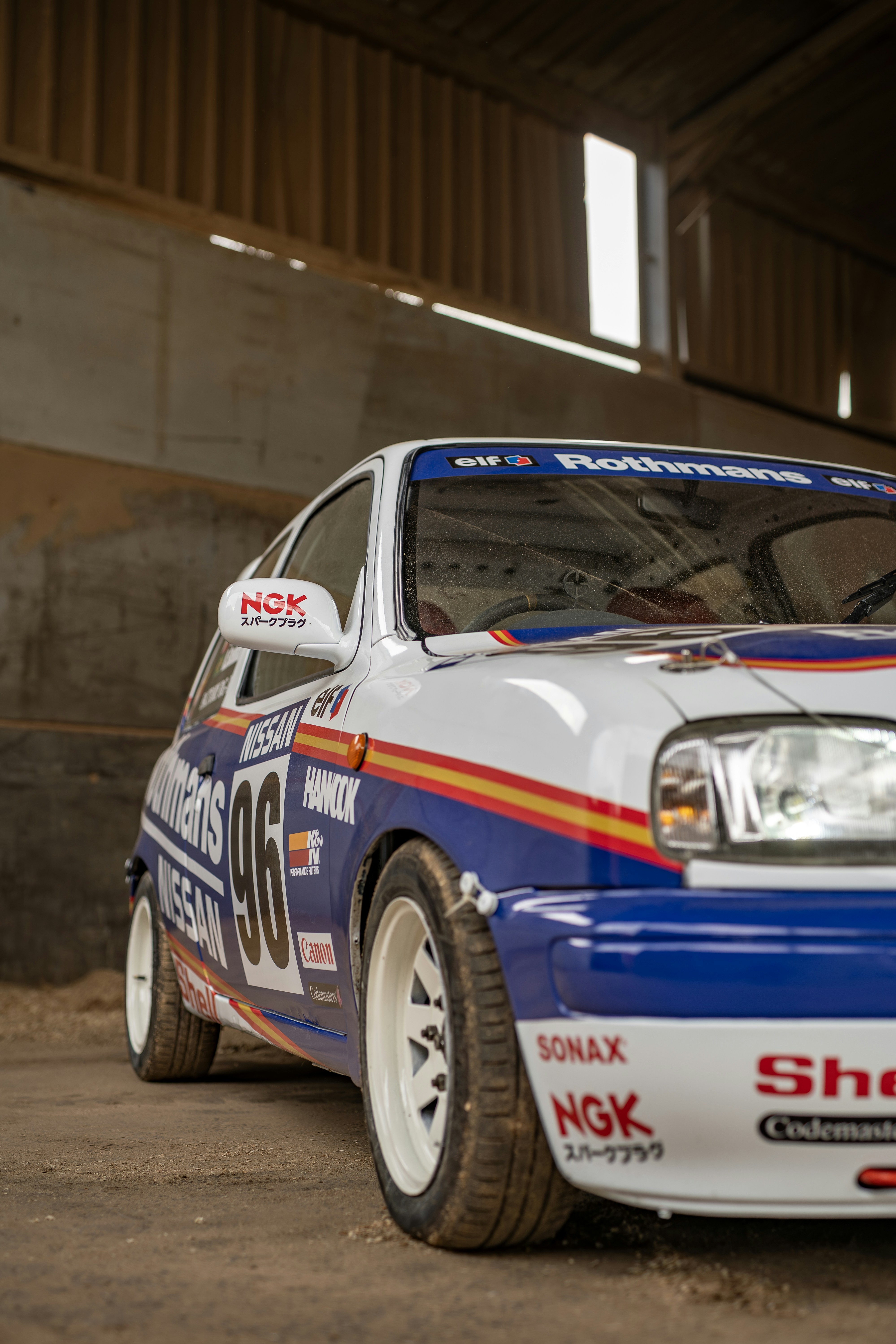 A classic racing car is parked inside a building.