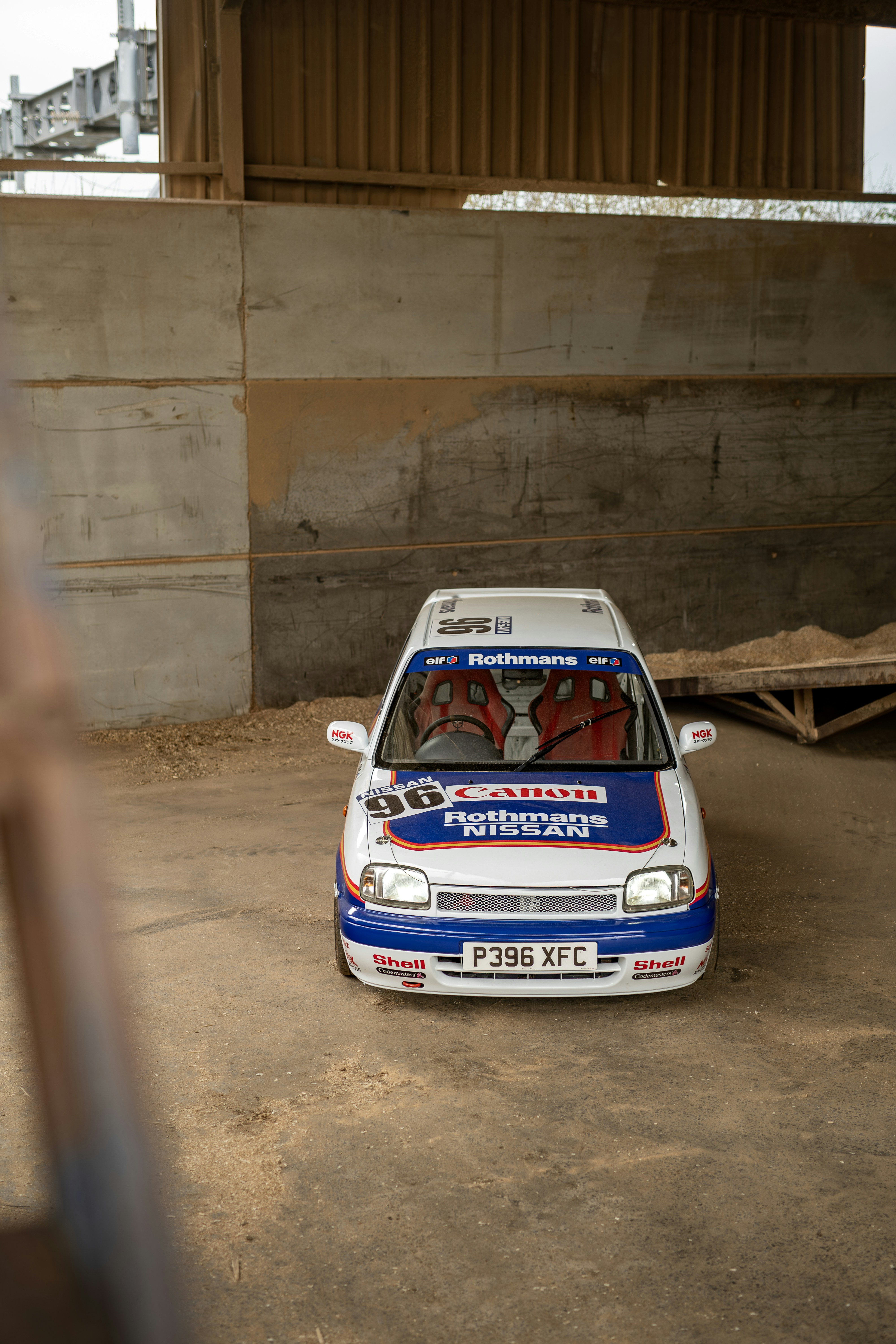 Race car inside a wooden barn.