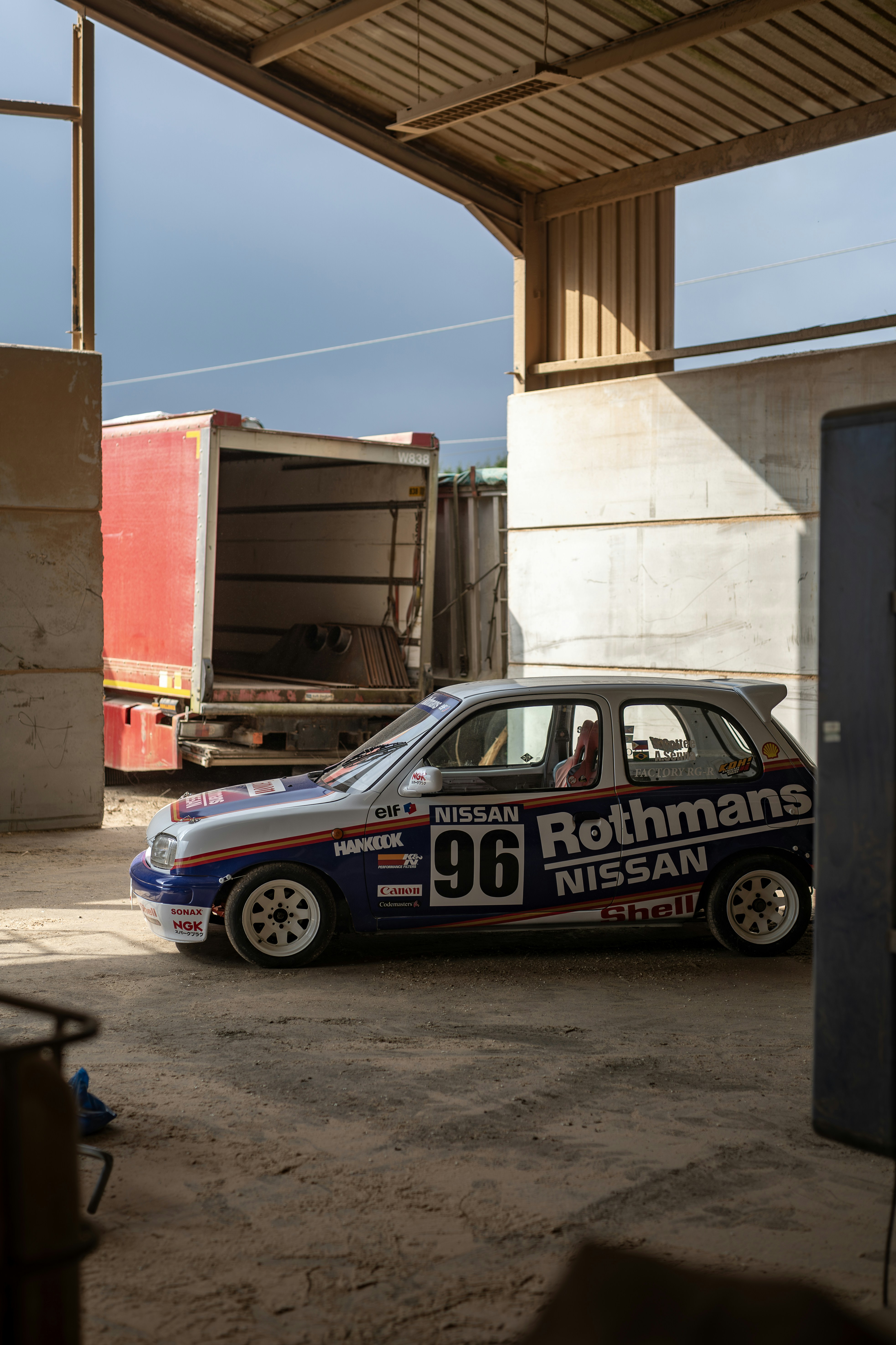 A racing car sits in a barn.