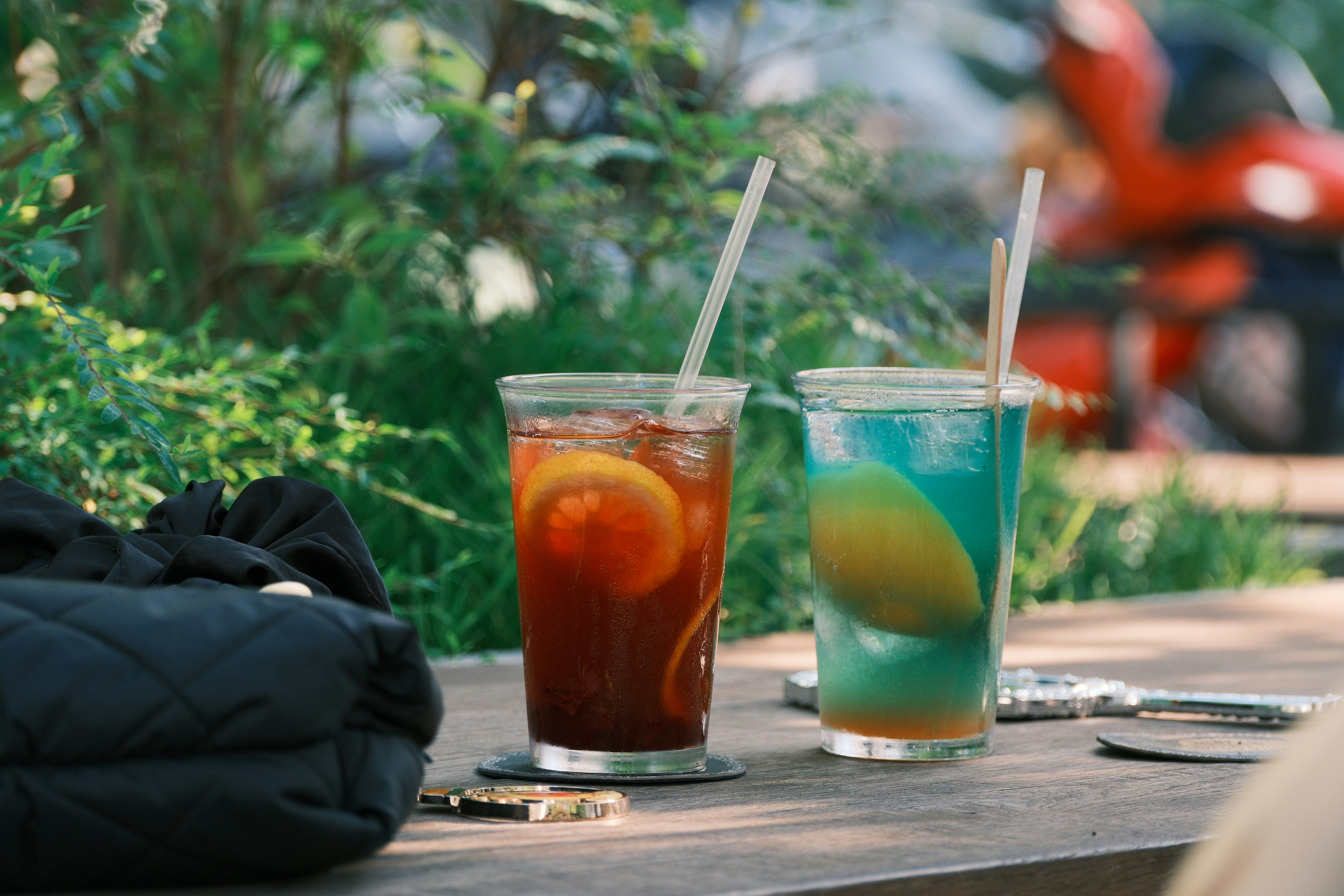 Two iced drinks with citrus on an outdoor table