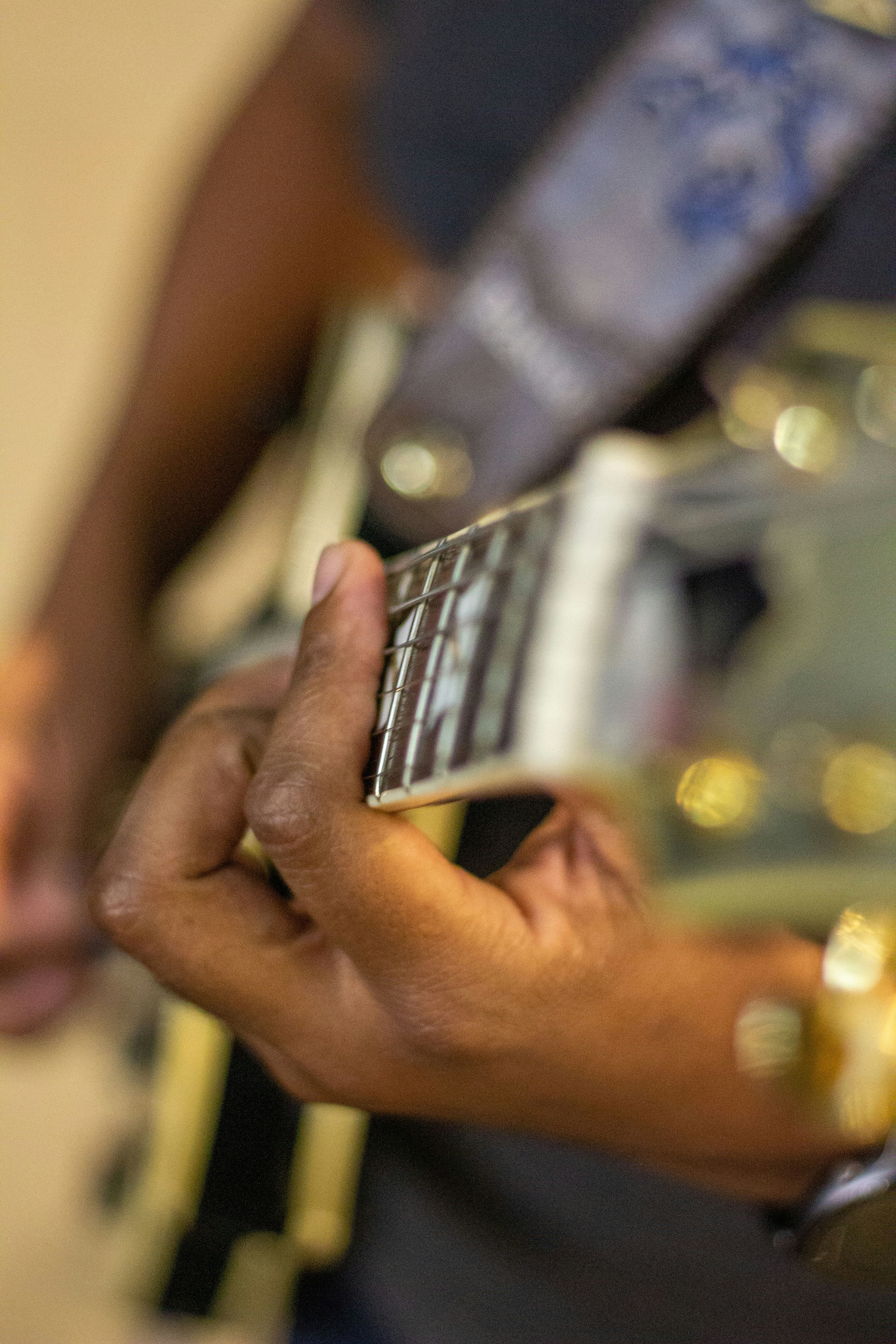 Una persona suona la chitarra, primo piano.
