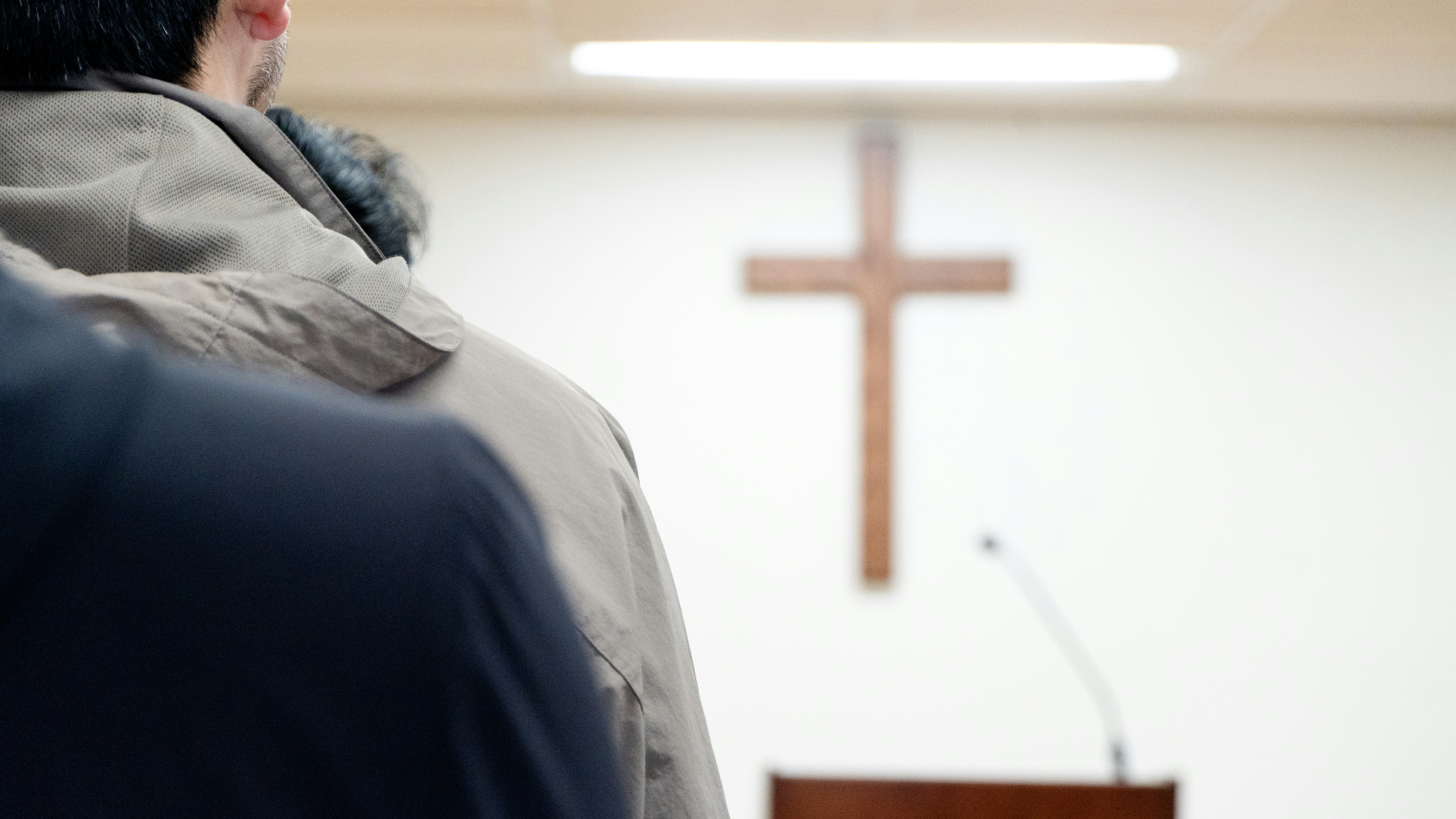 Someone is standing in front of a church cross.