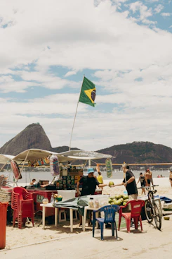 A beach vendor sells coconuts under the brazilian flag
