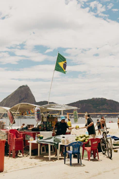 A beach vendor sells coconuts under the brazilian flag