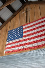 American flag and a cross hanging on wood.