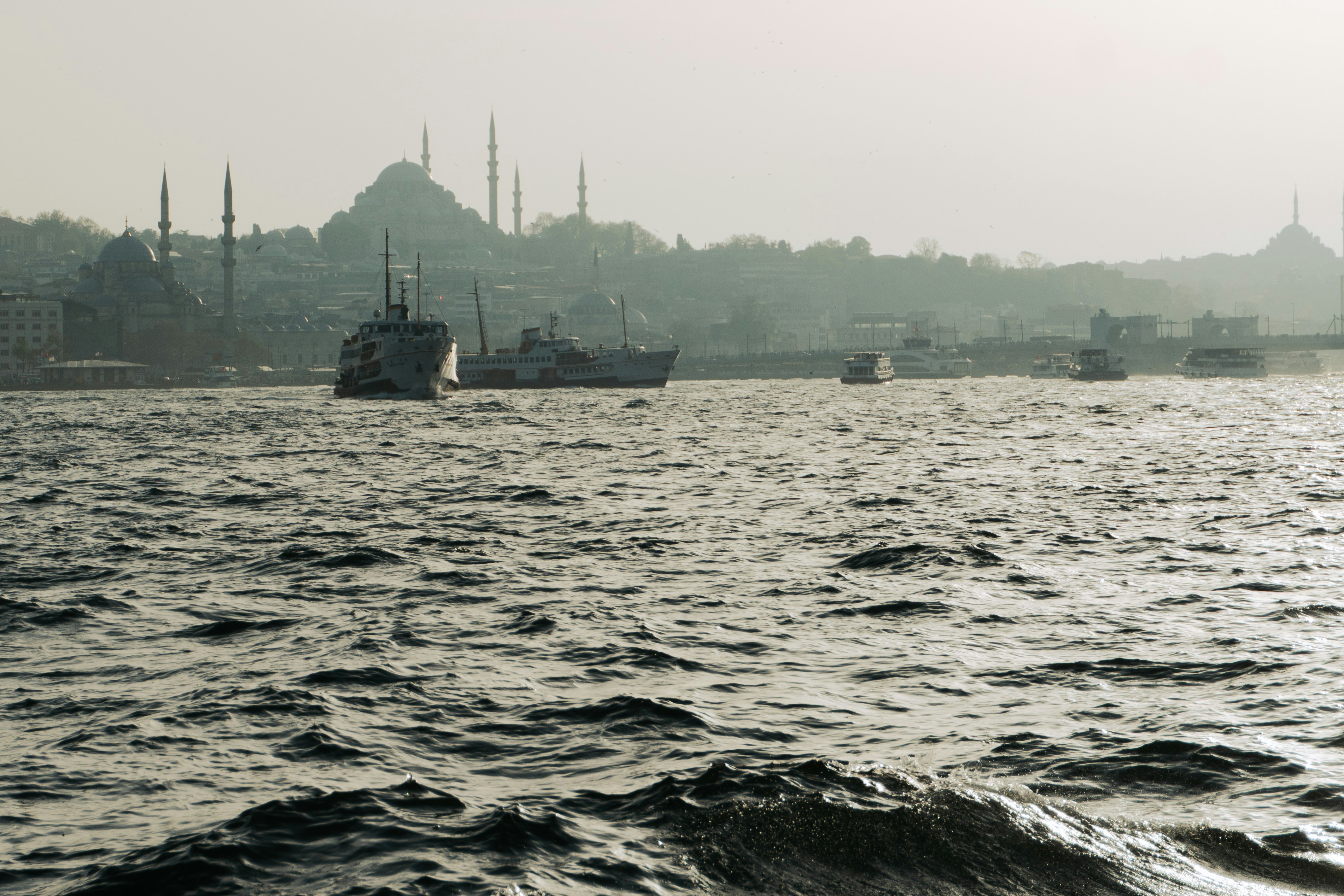 Boats sail on water near the skyline of istanbul.