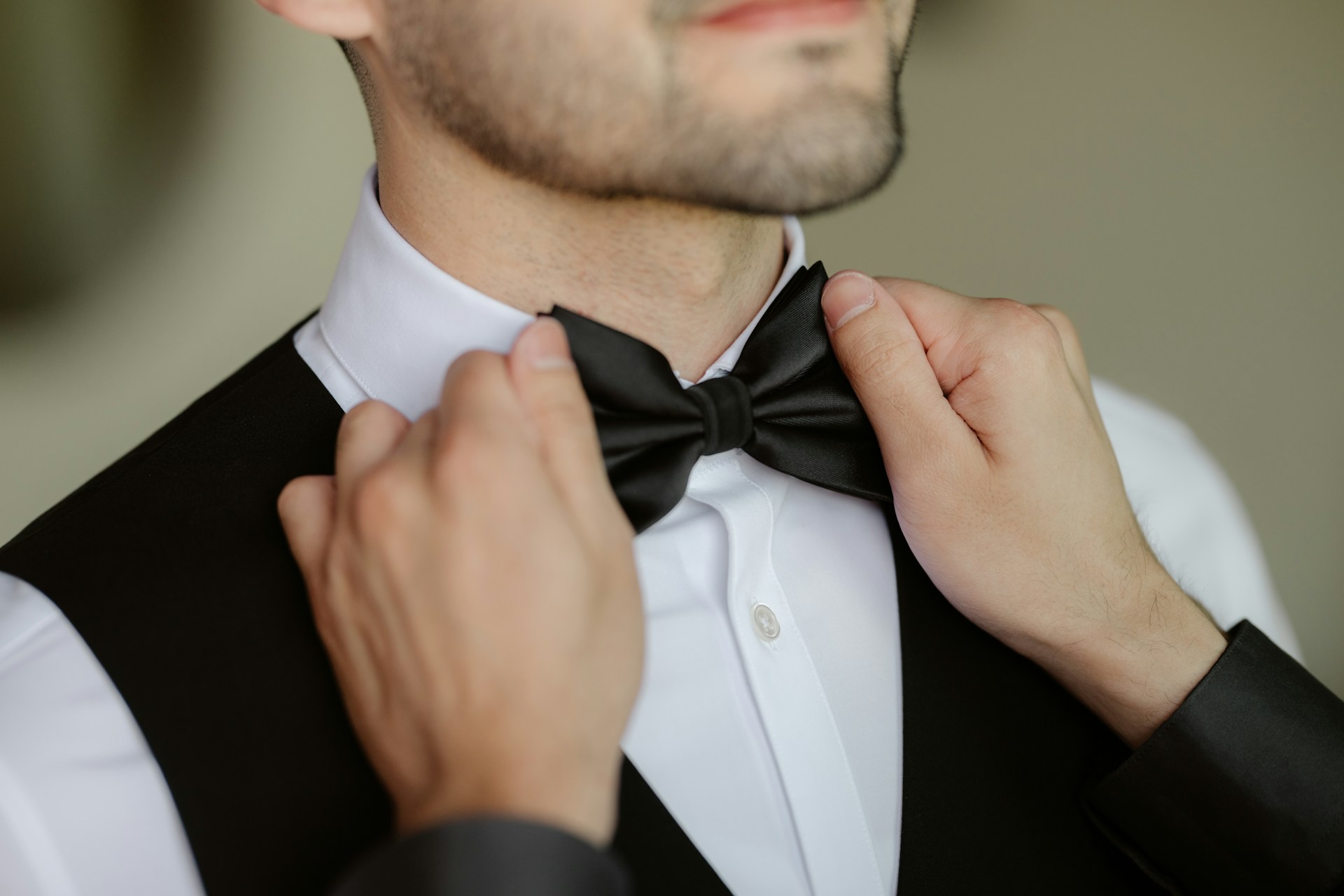 A man adjusts his bow tie.
