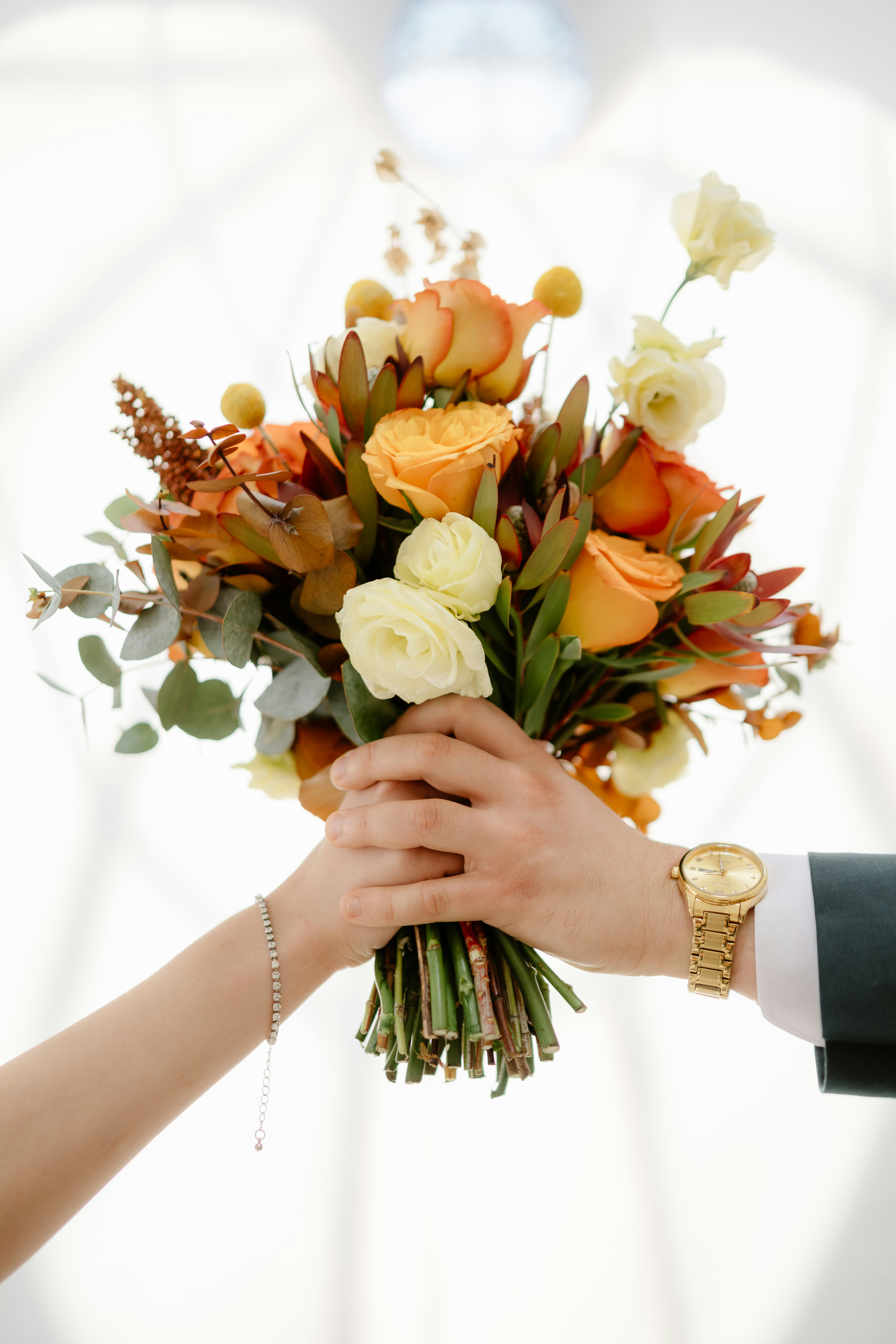 Couple holding a beautiful bouquet of flowers.