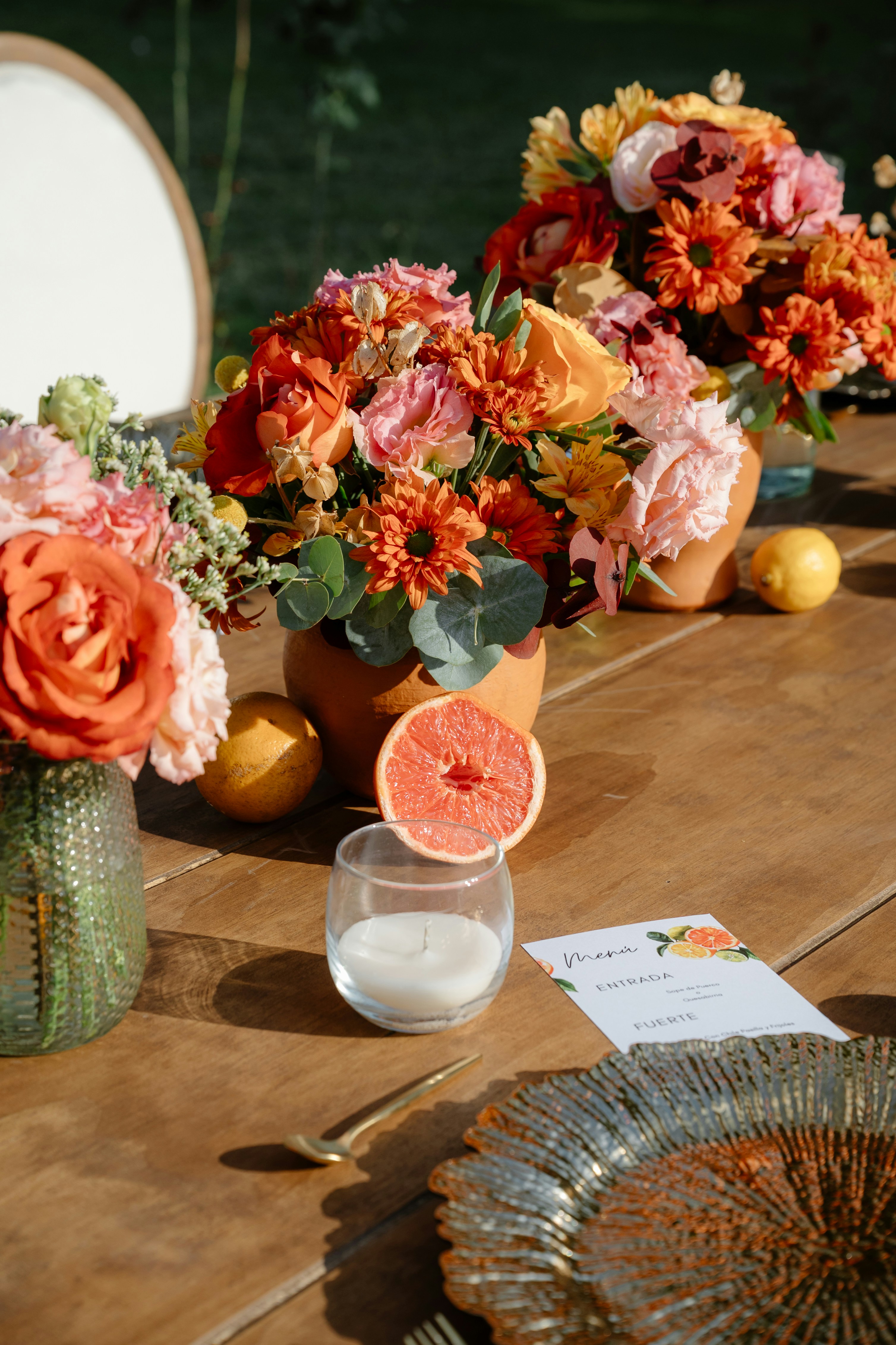 Flowers and fruit decorate a beautifully set table.