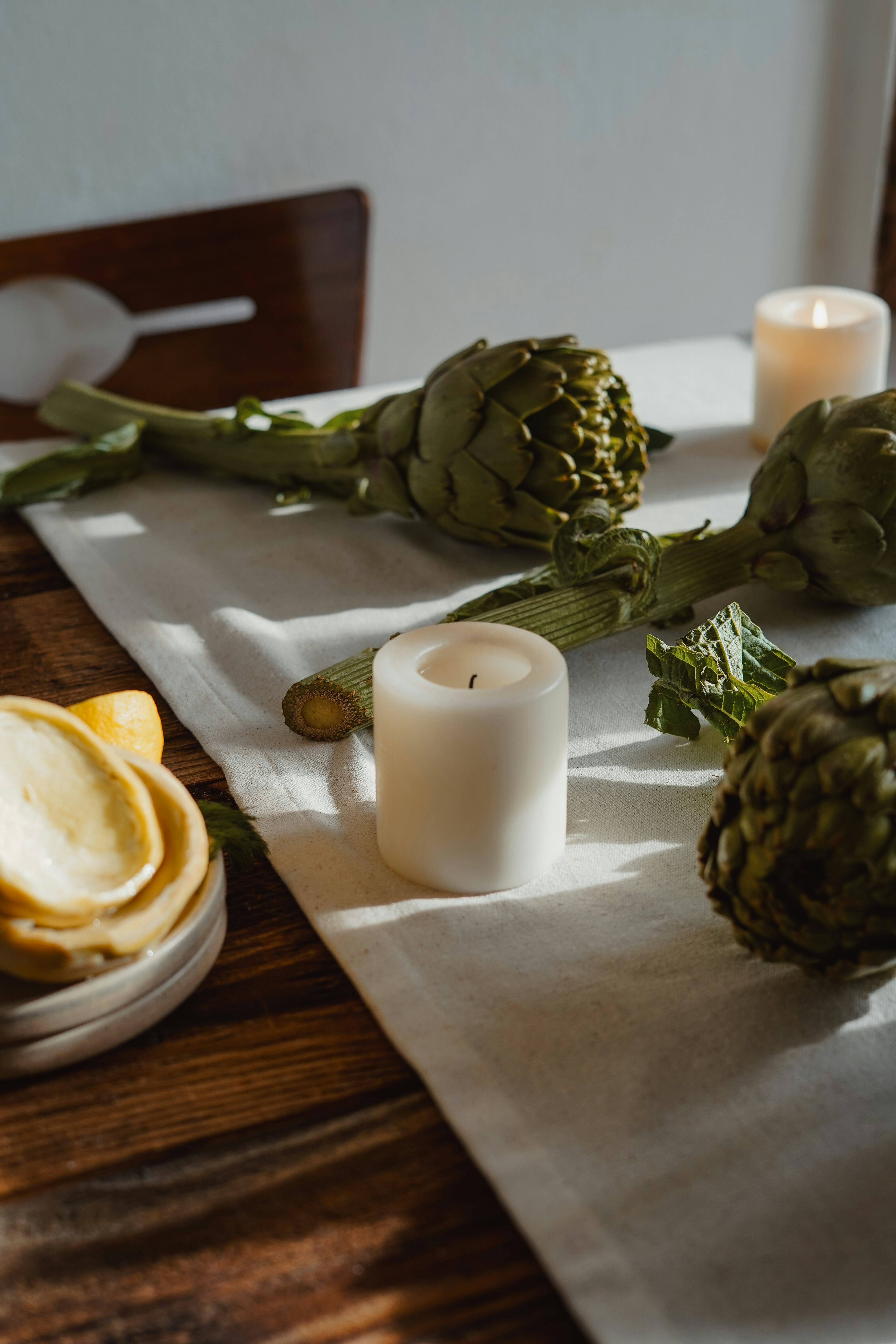 Artischocken und Kerzen bilden ein schlichtes, elegantes Mittelstück.