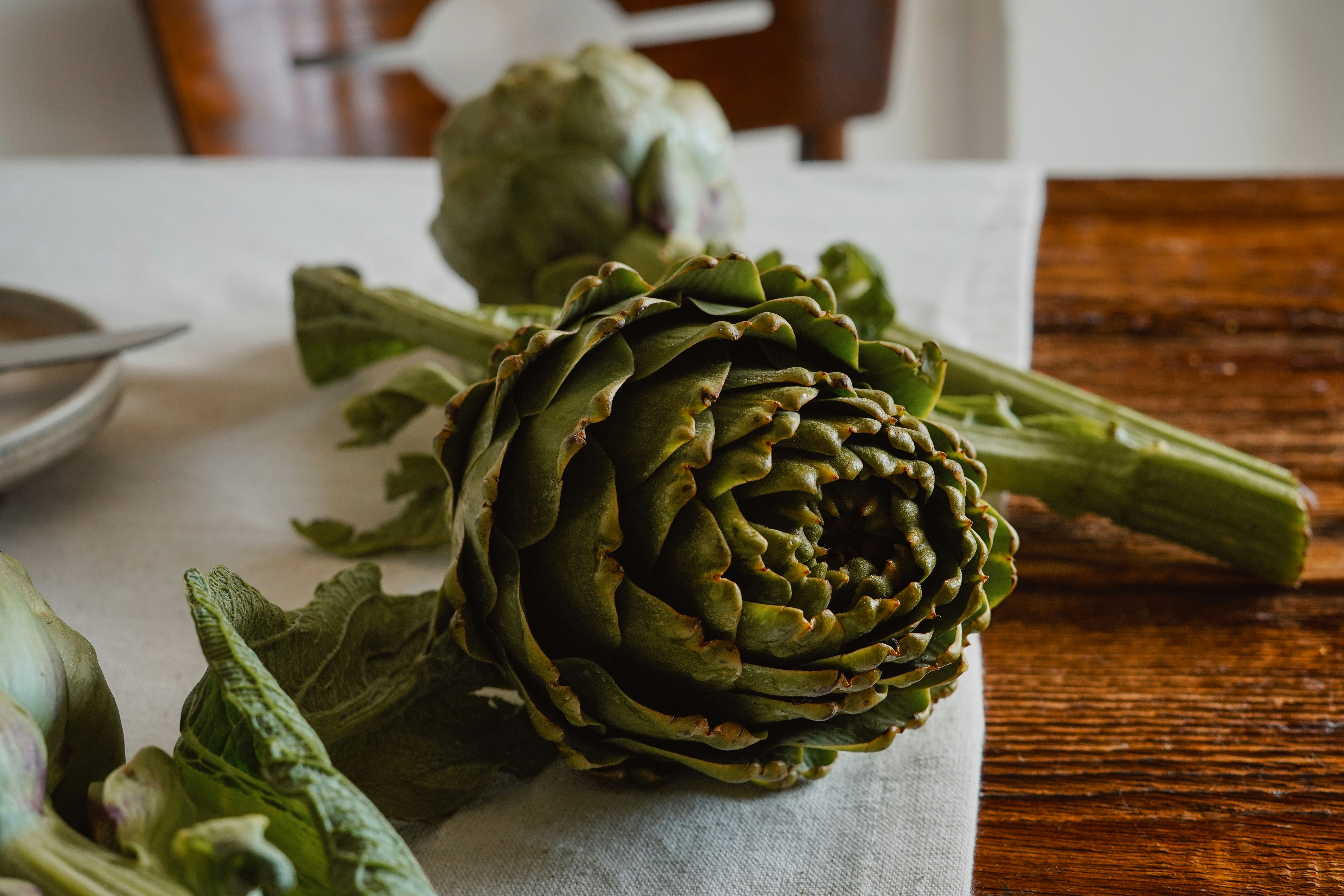 Frische Artischocken auf einem Holztisch.