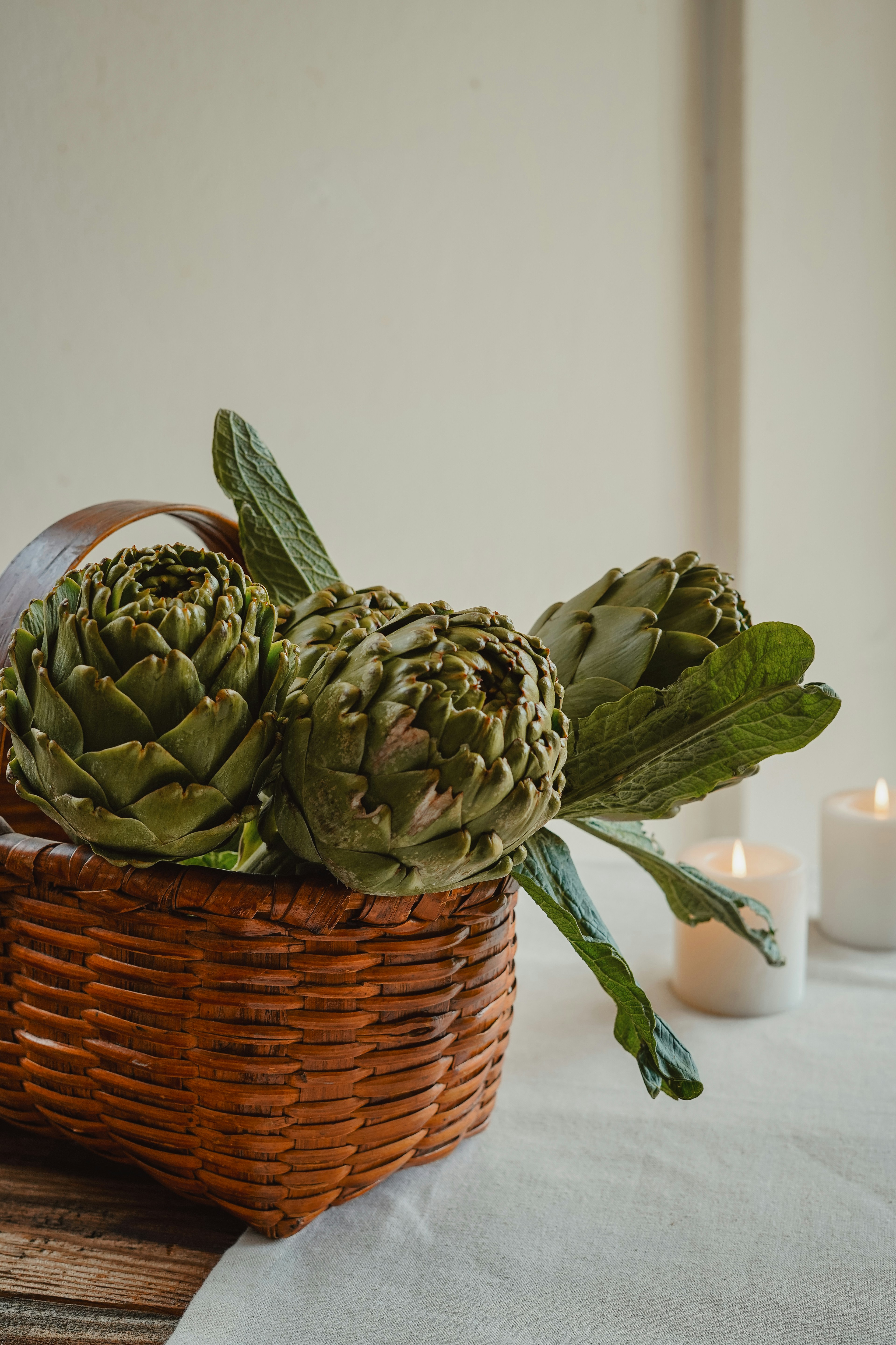 Frische Artischocken ruhen in einem Weidenkorb.