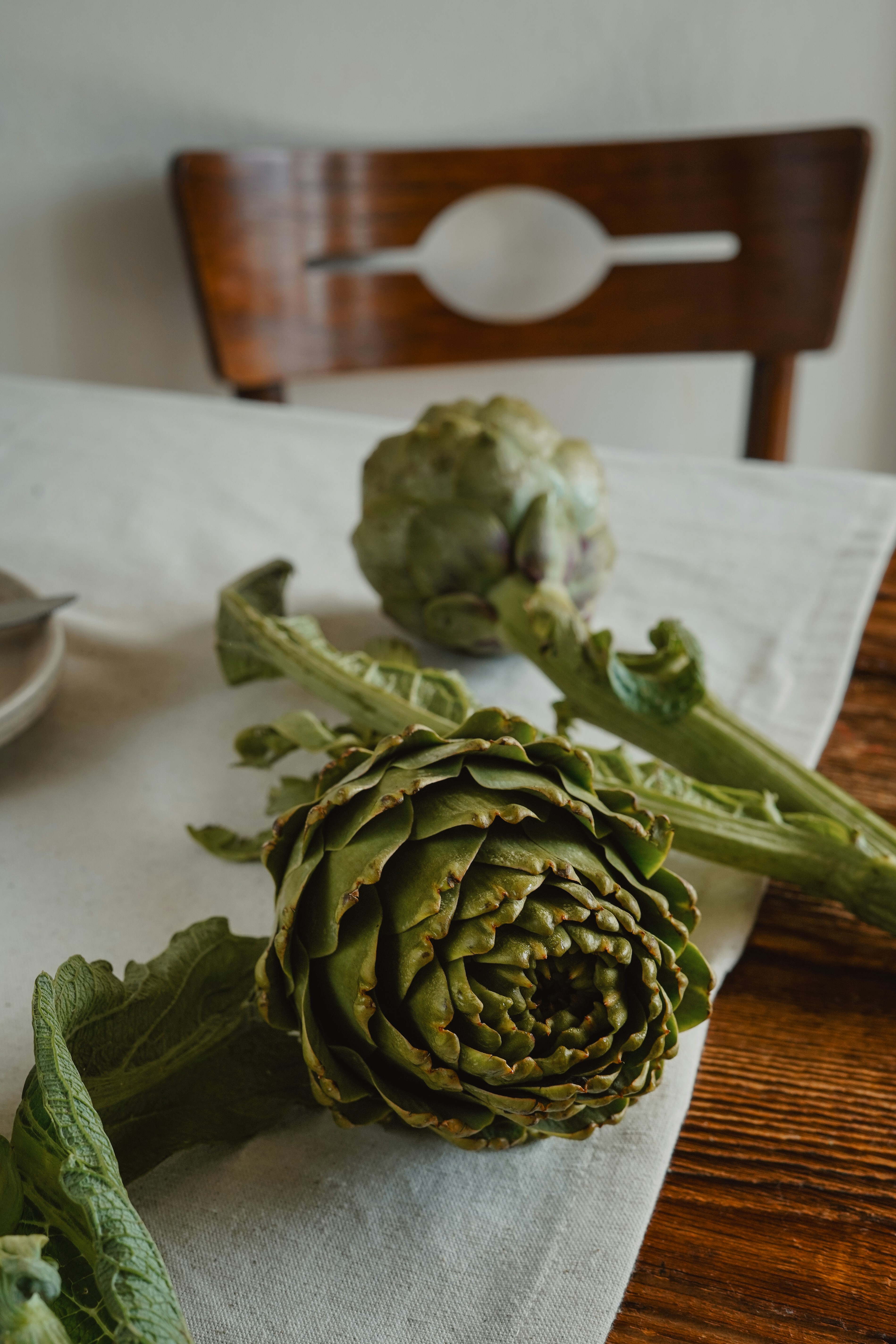 Frische Artischocken ruhen auf einem Tisch.