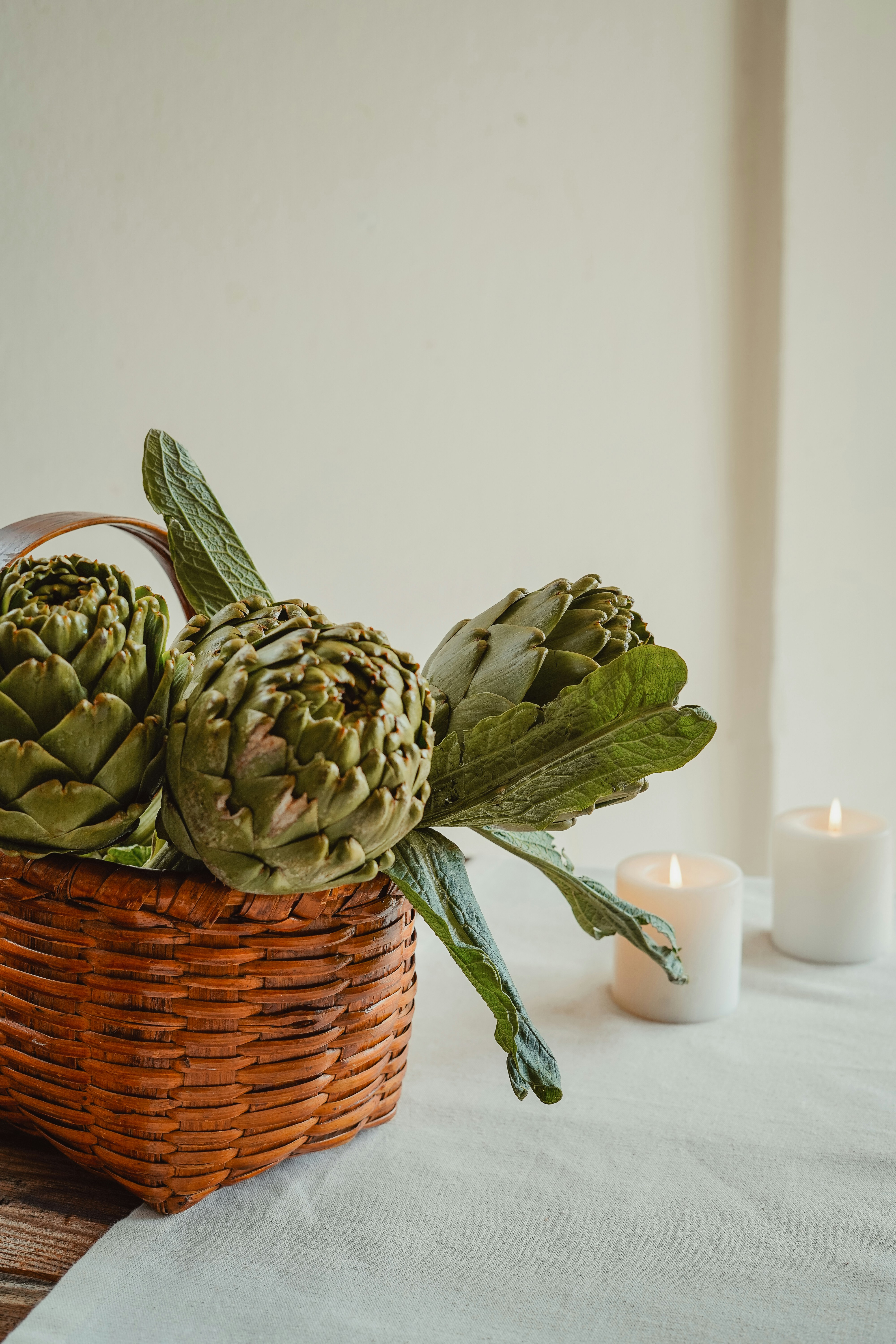 Artischocken in einem Korb mit Kerzen.