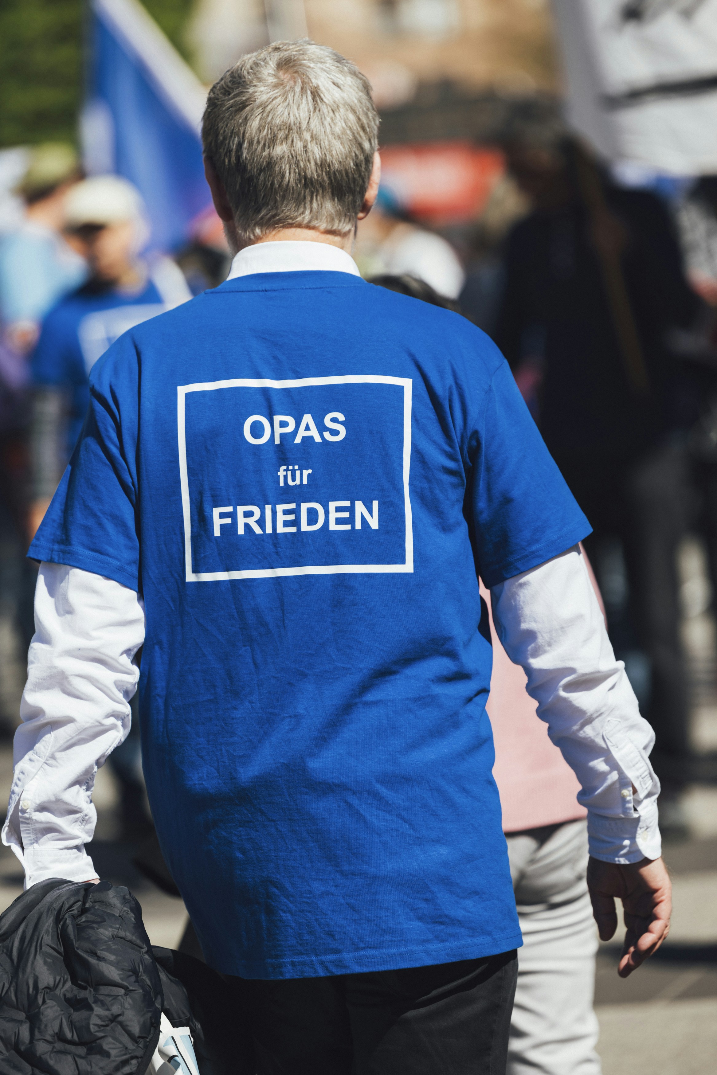 Man wears a shirt advocating for peace.