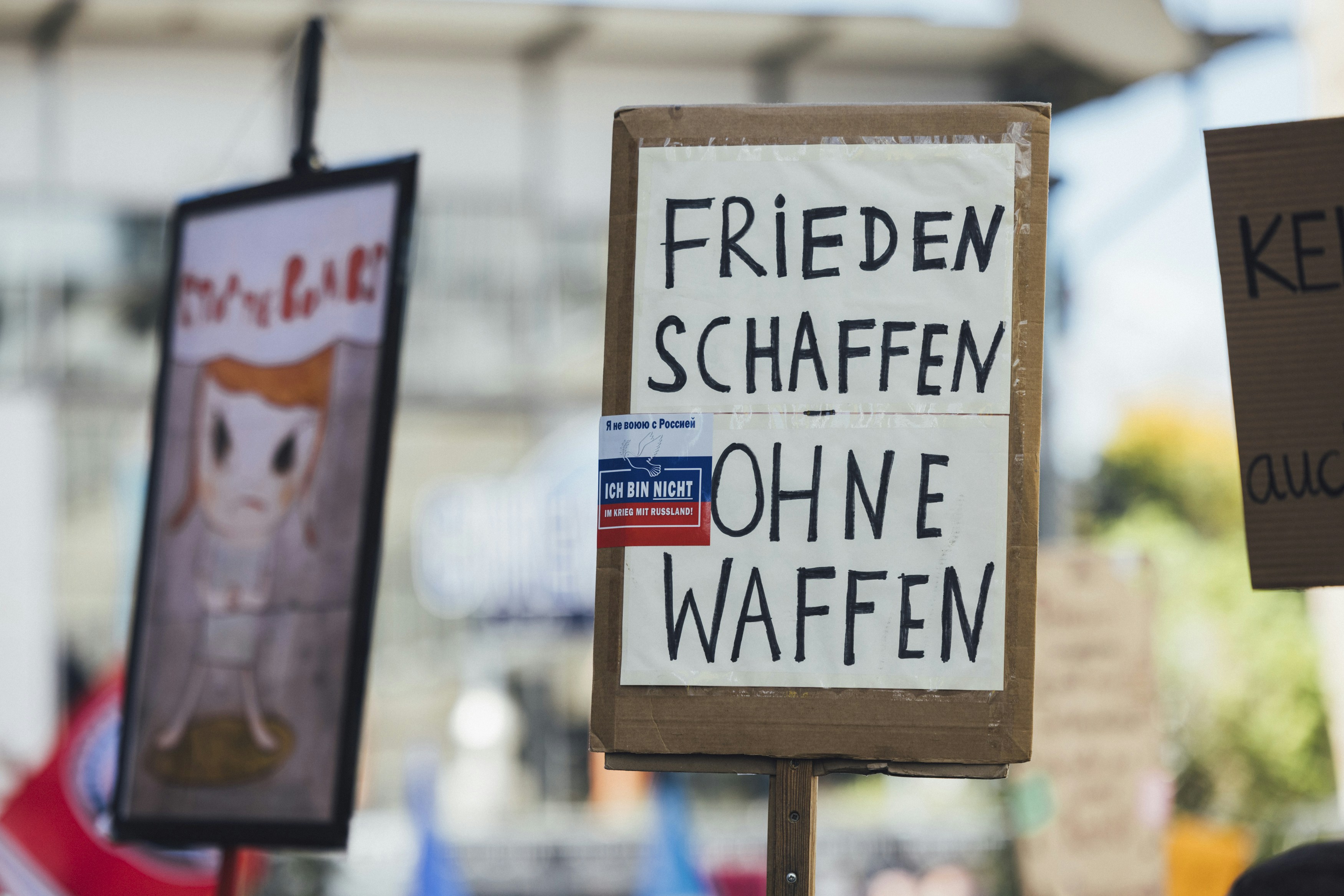 Signs read "create peace without weapons."