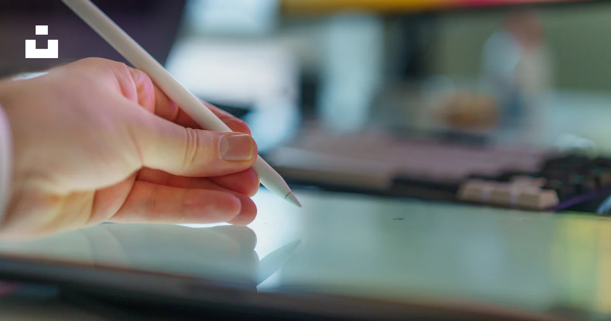 A hand holds a stylus above a tablet. photo – Free Office Image on Unsplash