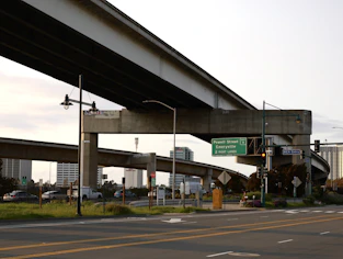 An elevated highway structure stands over the road.