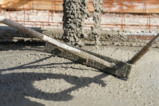 Concrete is being leveled with a screed.
