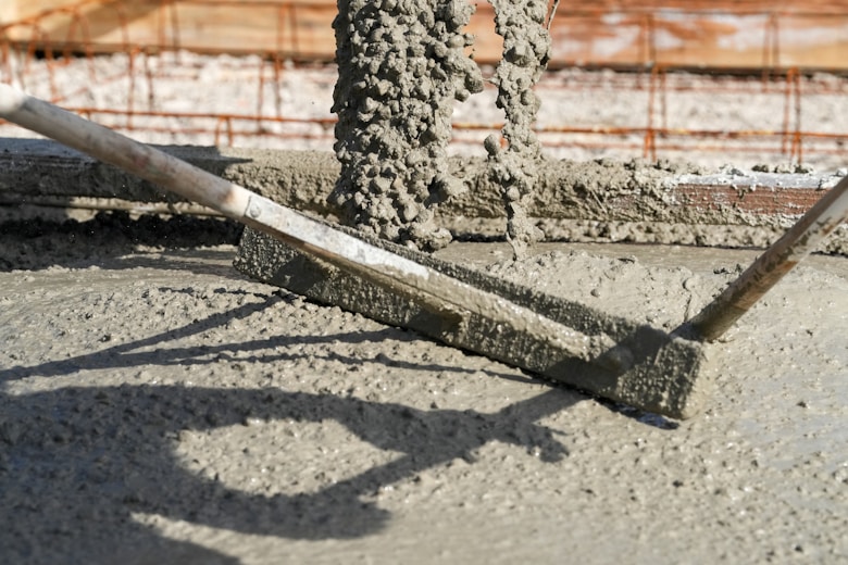 Concrete is being leveled with a screed.