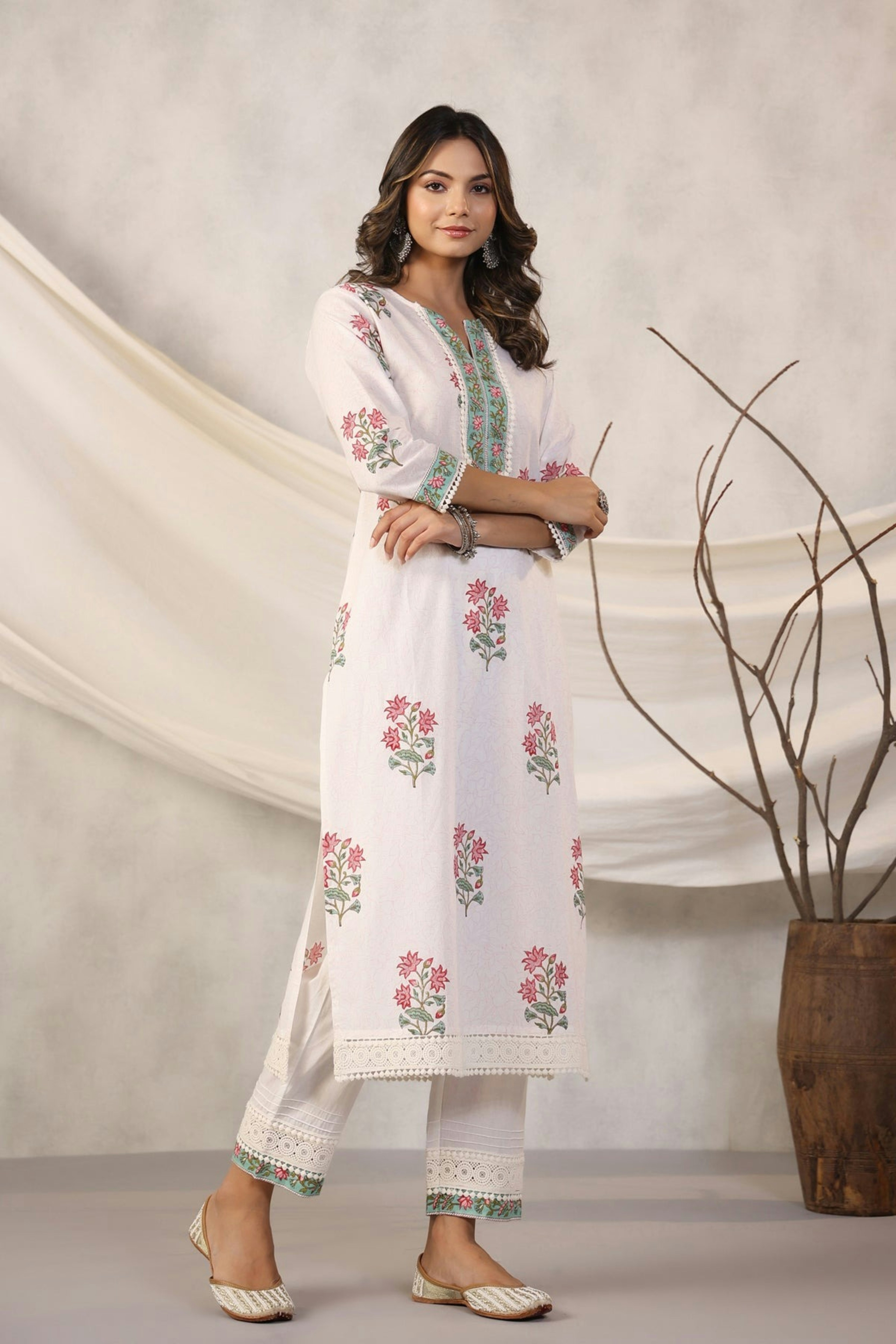 Woman models a white floral kurta pajama.