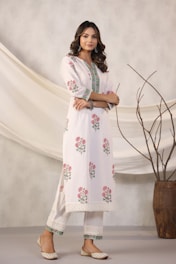 Woman models a white floral kurta pajama.
