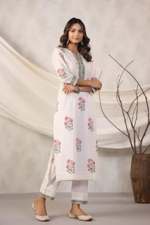 Woman models a white floral kurta pajama.