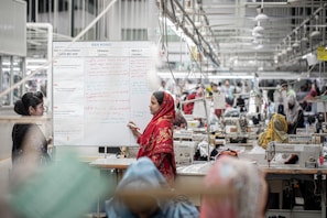 A woman in a factory stands by a whiteboard.