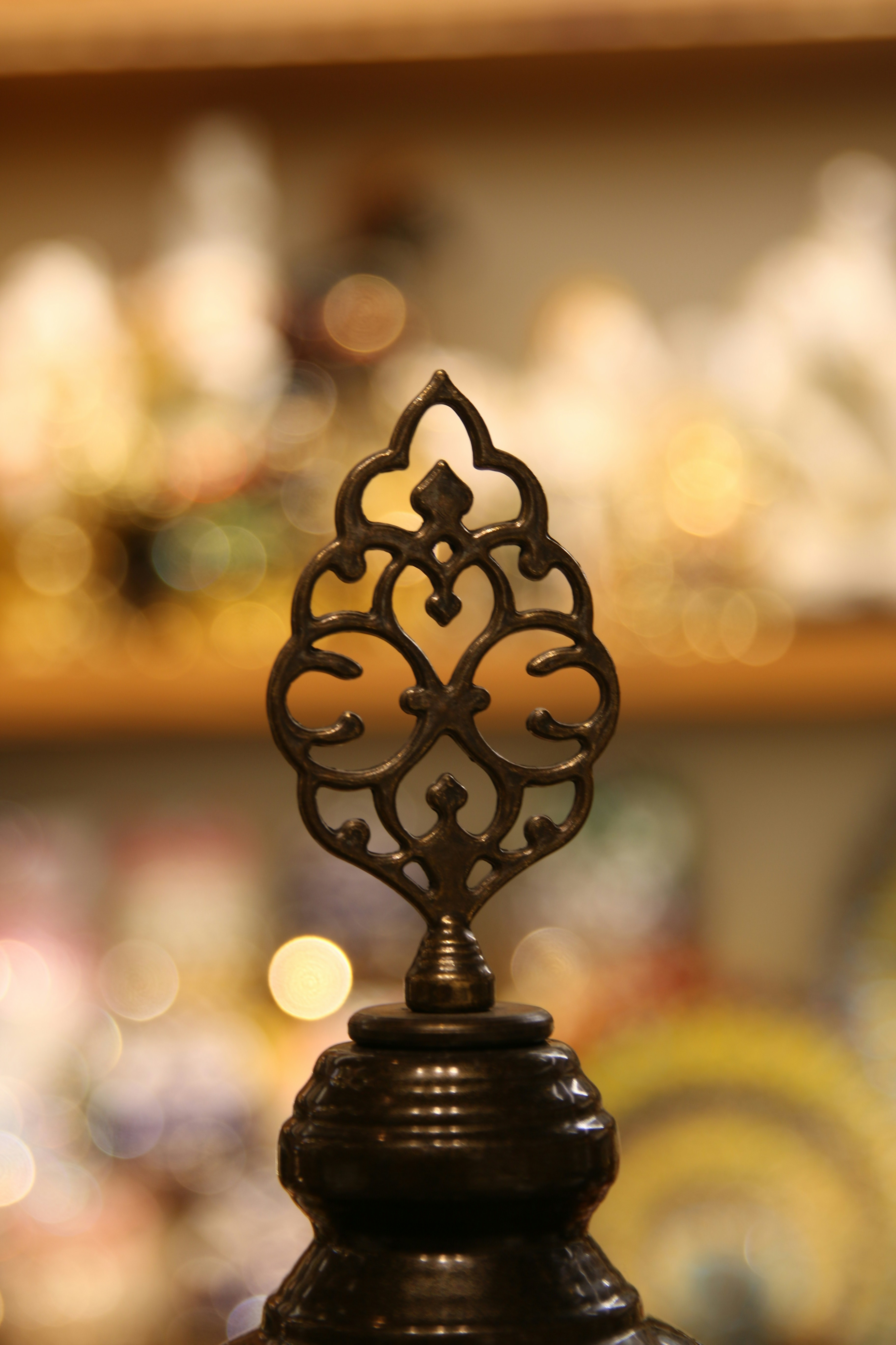 Decorative, ornate metal object with a blurry background.