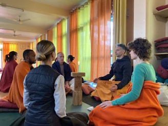 People are meditating in a sunny and colorful room.