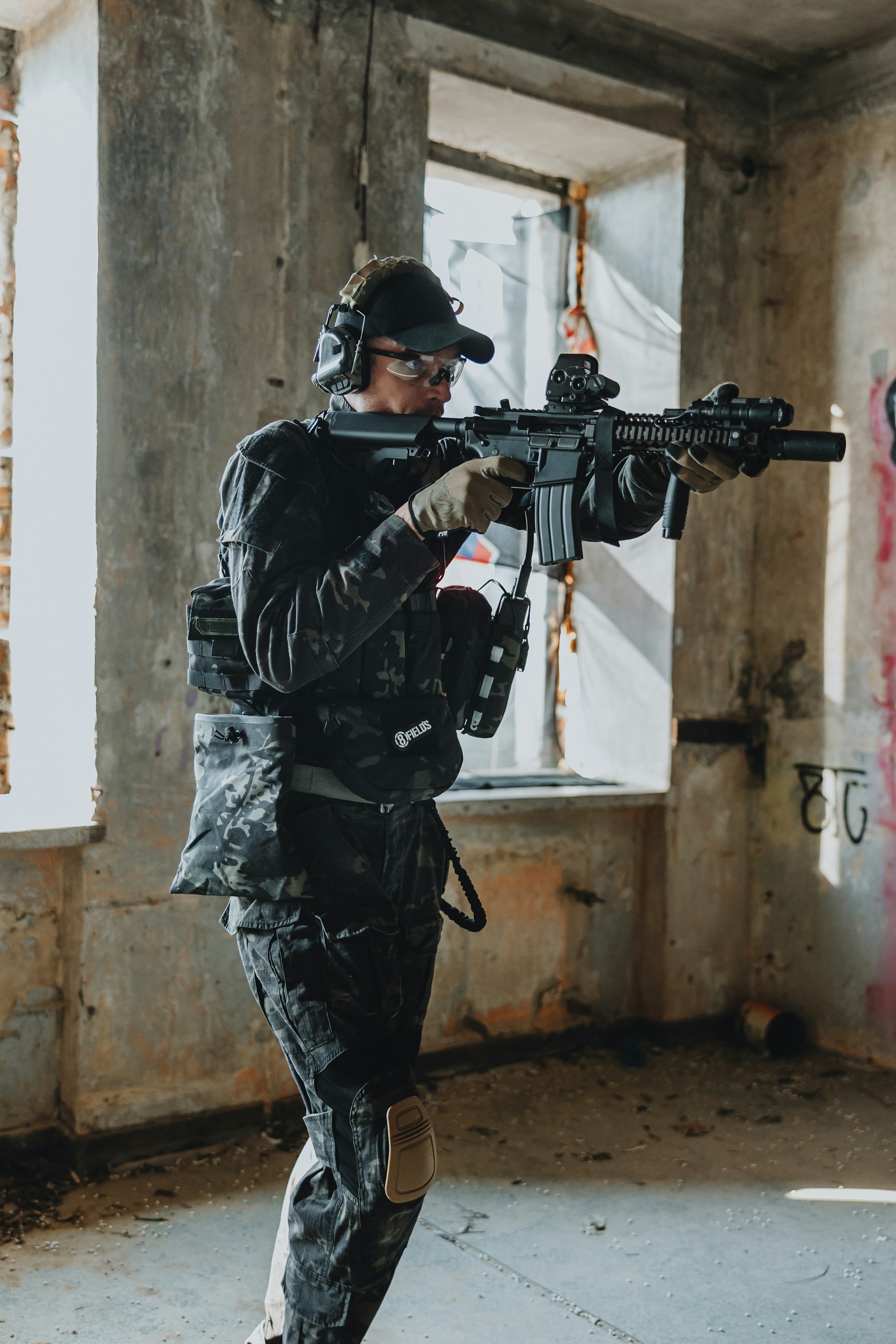 A soldier aims their weapon inside a building.