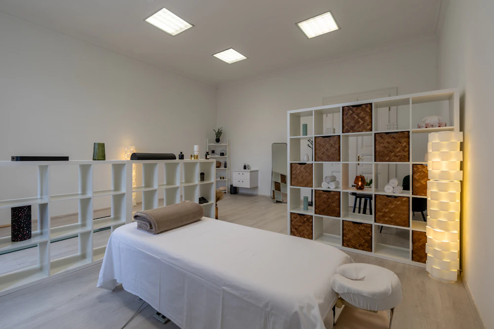 A softly lit massage room with the table made up and ready for a session