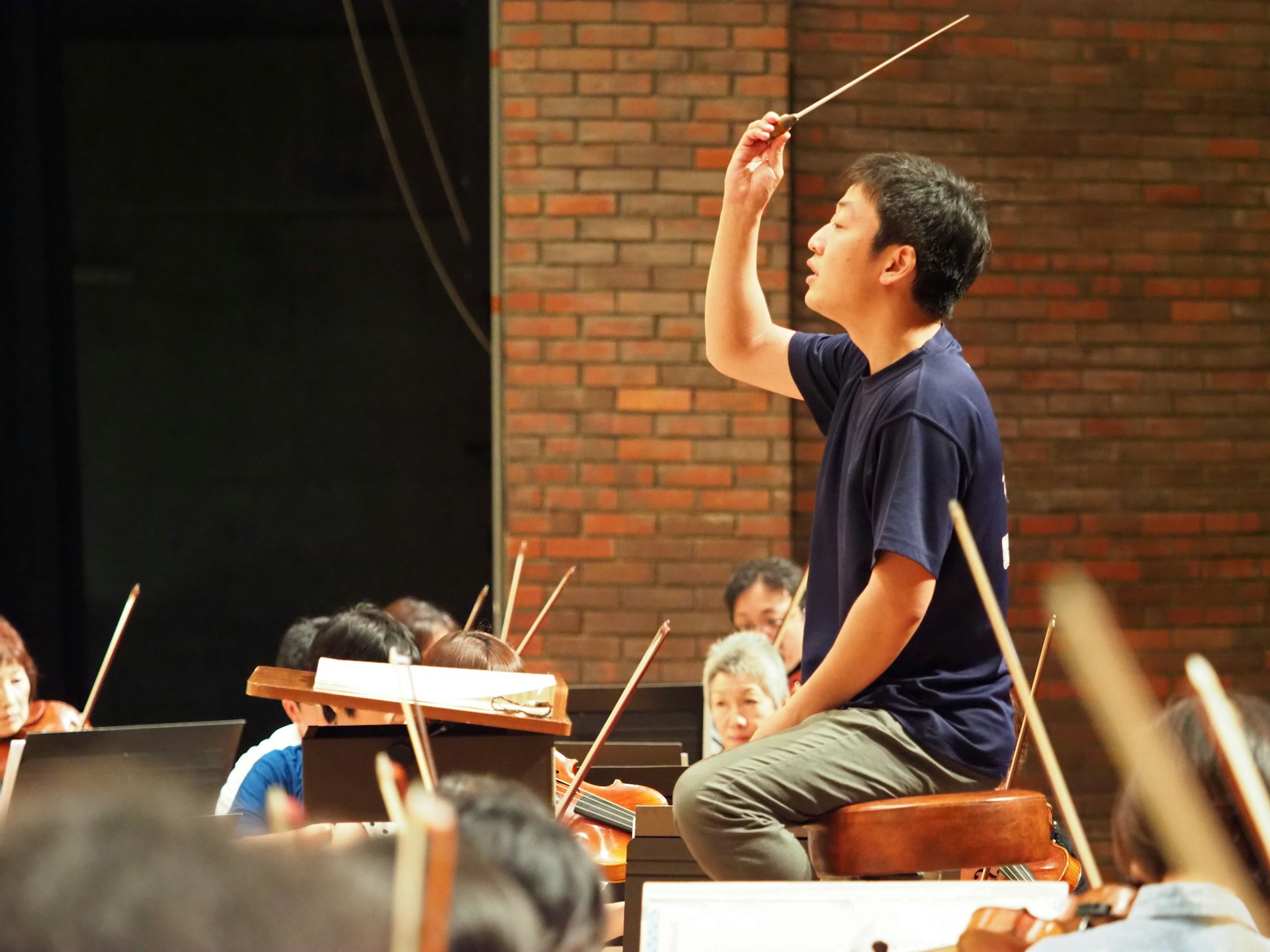 A conductor directs an orchestra with a baton.