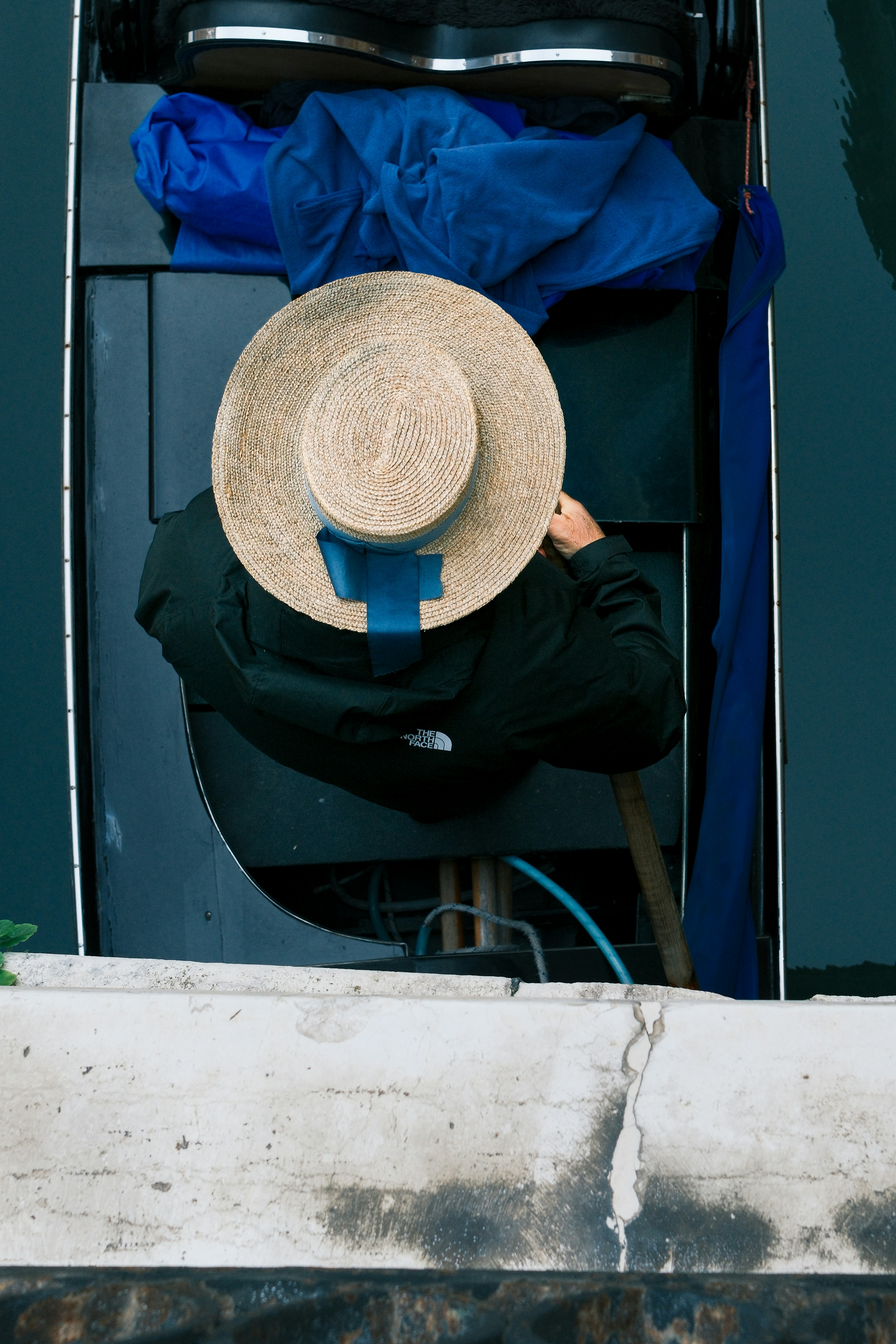 Un gondolier portant un chapeau est dans une gondole.