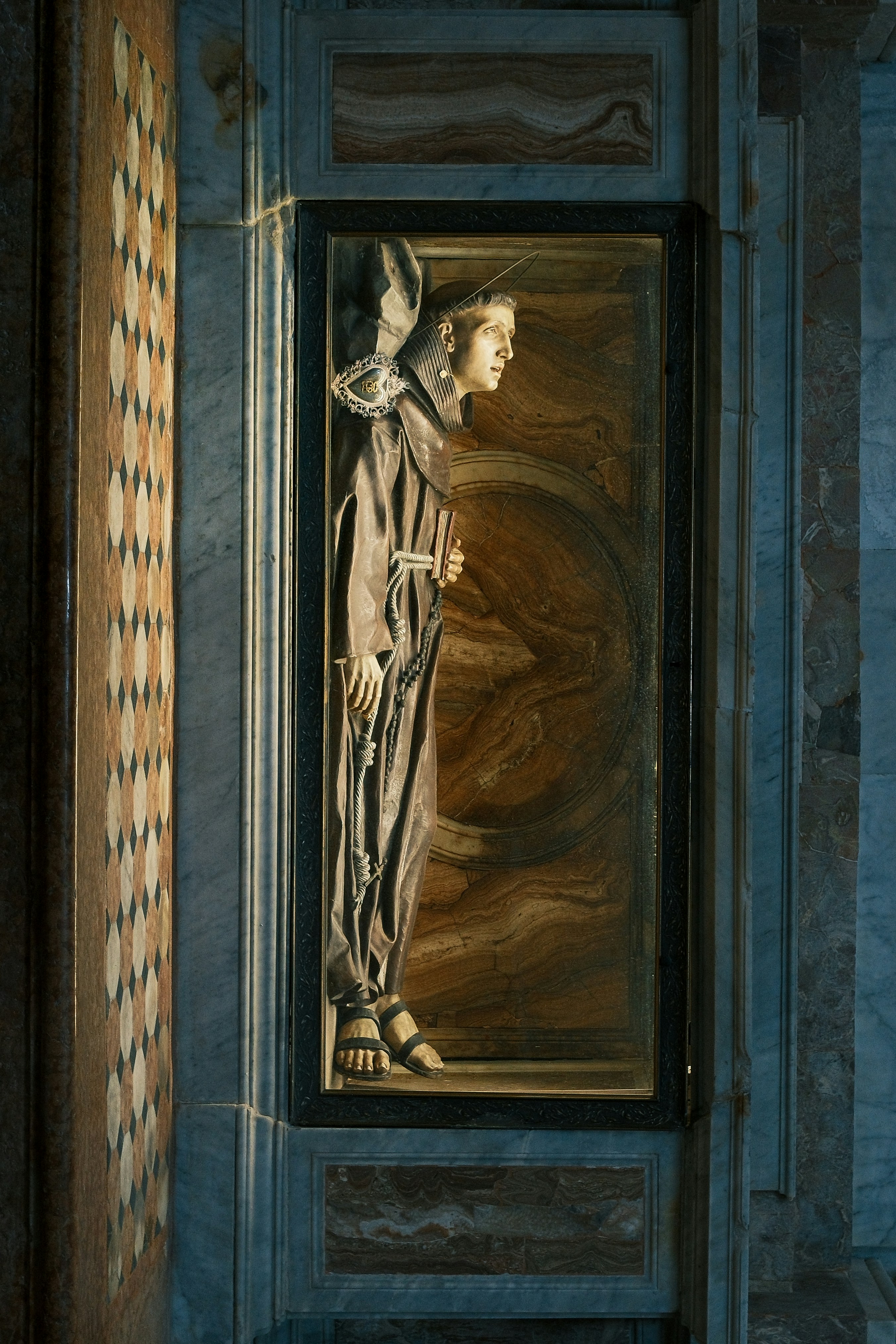 A carved statue of a man is in a niche.