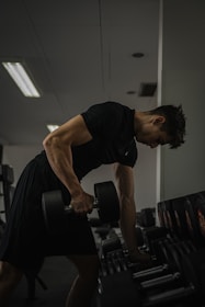 A man lifts a dumbbell at the gym.
