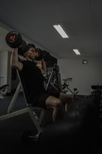 Man works out at the gym lifting weights.
