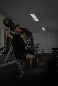 Man works out at the gym lifting weights.