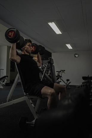 Man works out at the gym lifting weights.