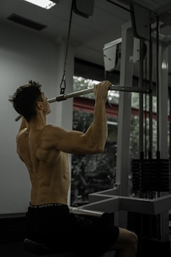 Man doing a lat pulldown exercise at the gym.