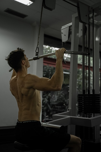 Man doing a lat pulldown exercise at the gym.