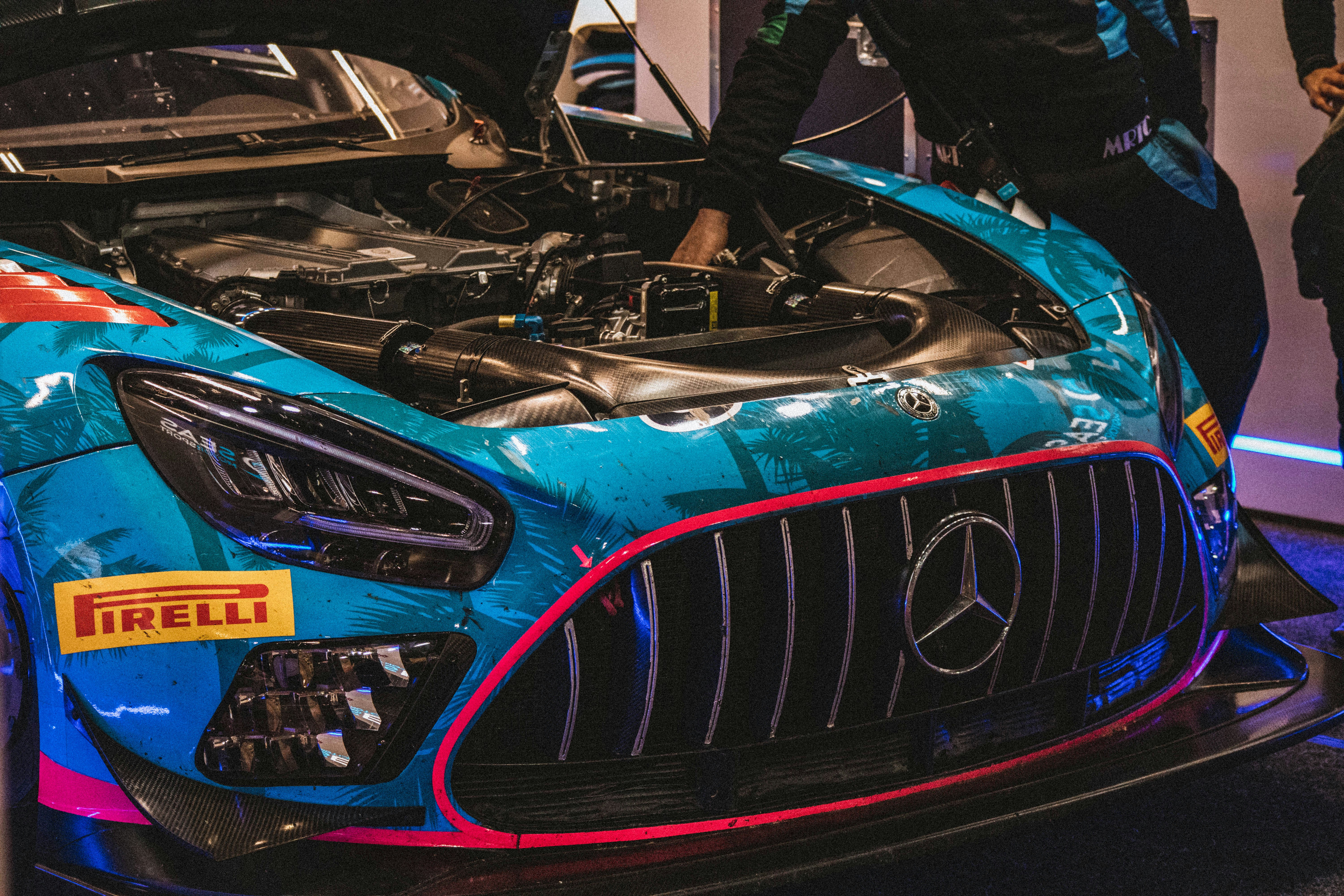 Mechanic inspecting the engine of a racing car, representing specialized service needs